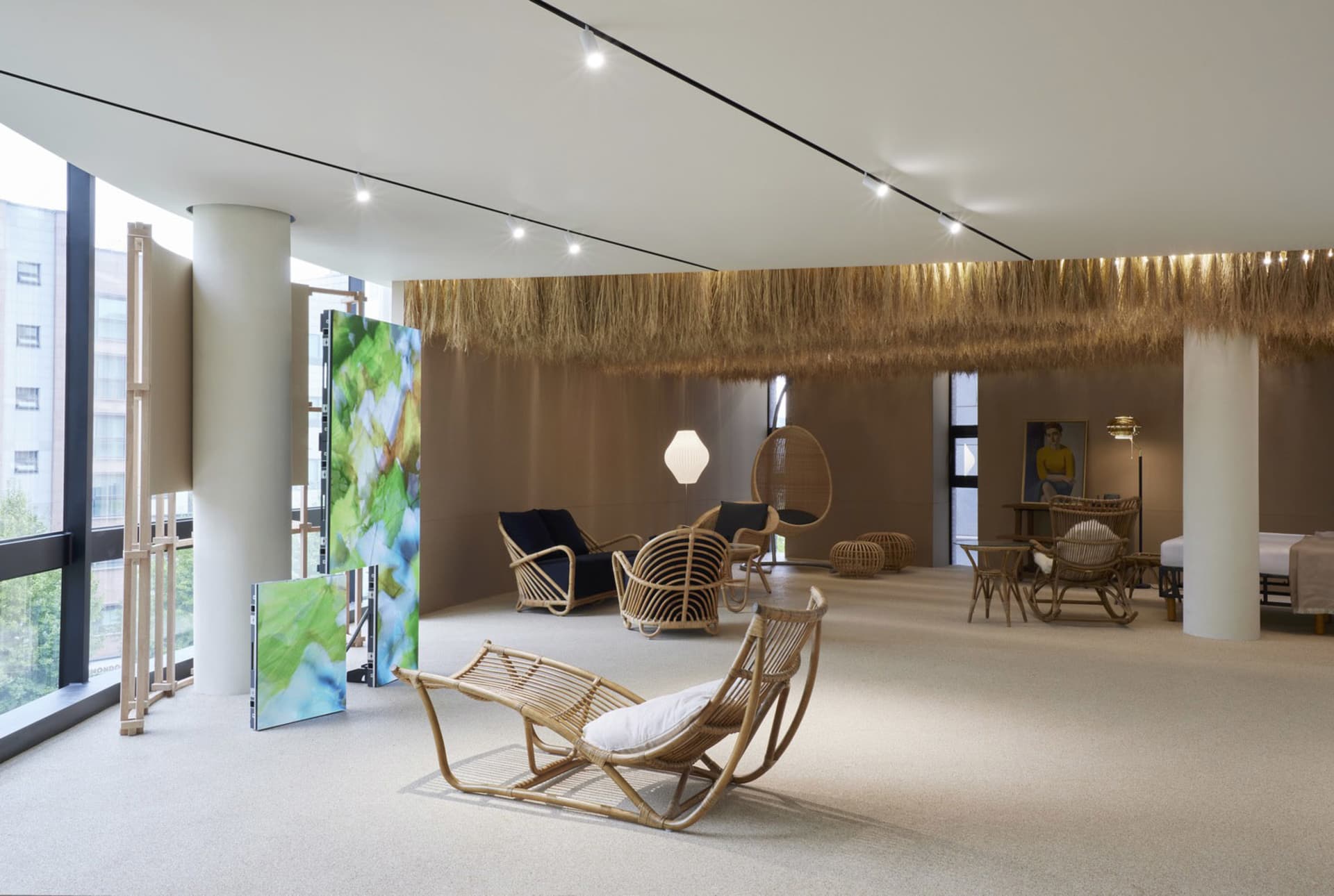 Modern interior design featuring rattan chairs and a straw ceiling with fabric accents.