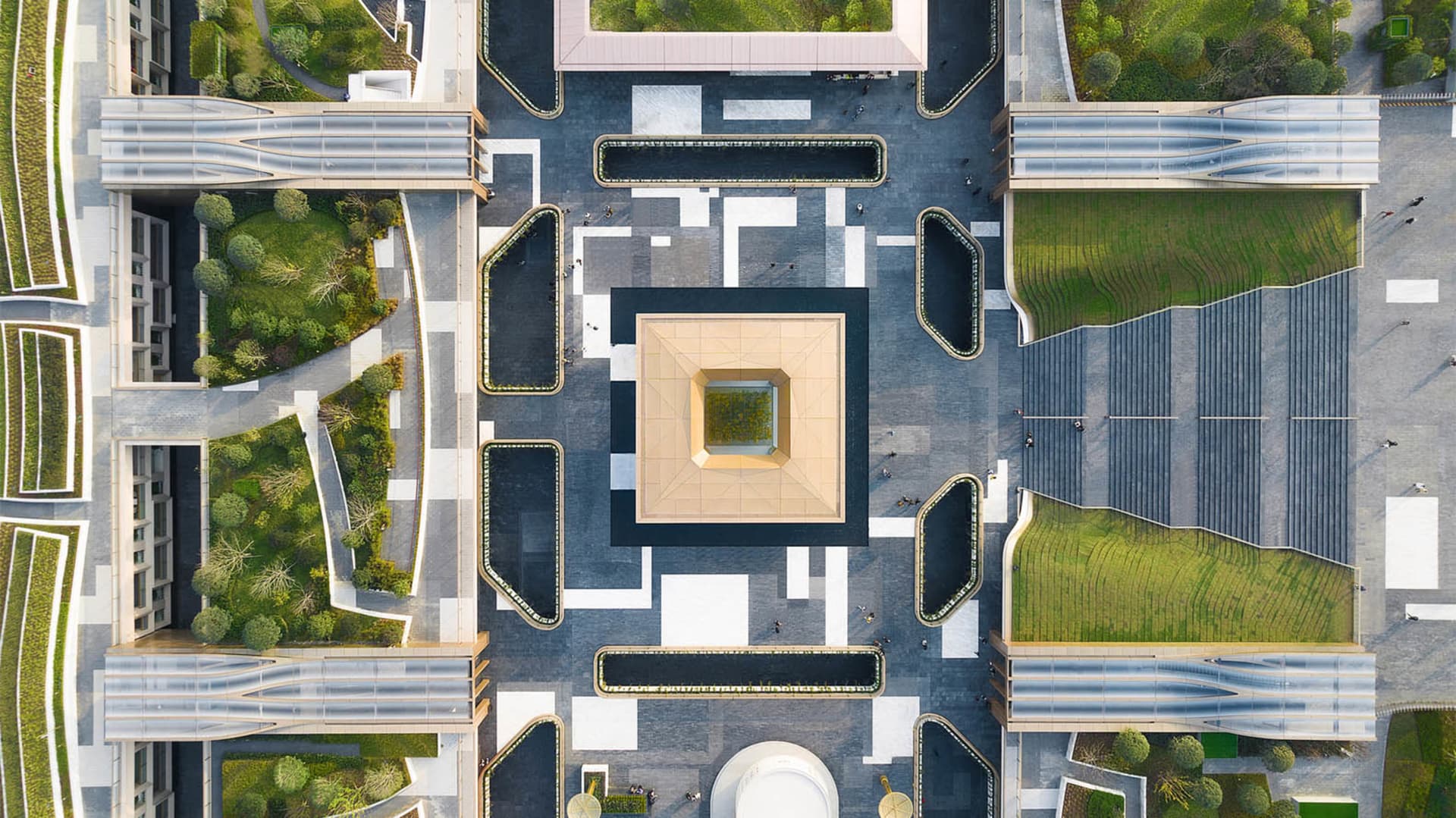 俯瞰現代公共空間，融合混凝土、草地與水景元素。