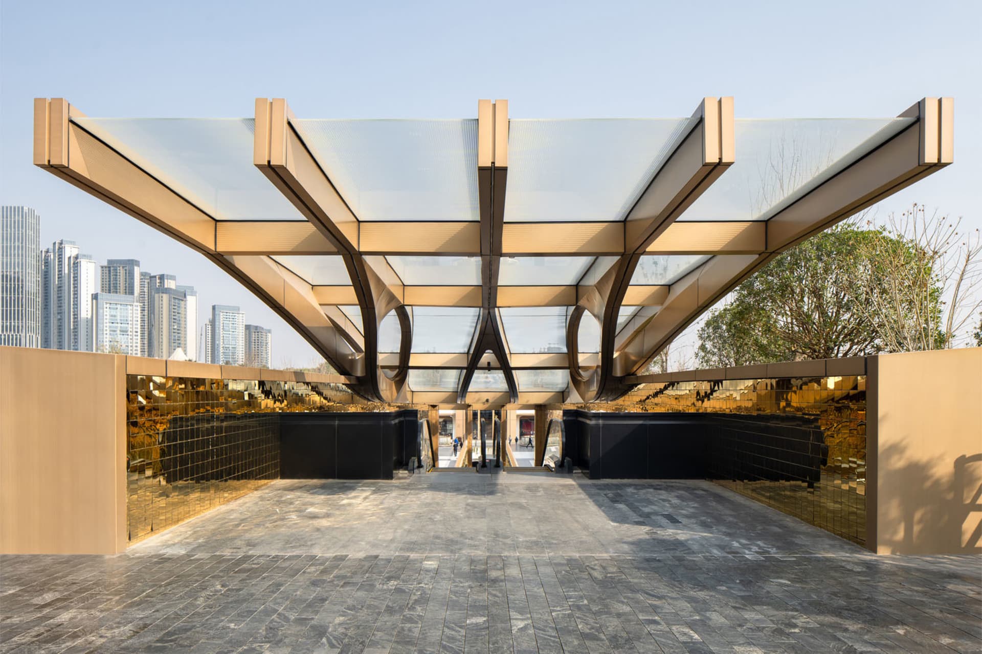 A modern public entrance featuring glass, metal, and cement materials