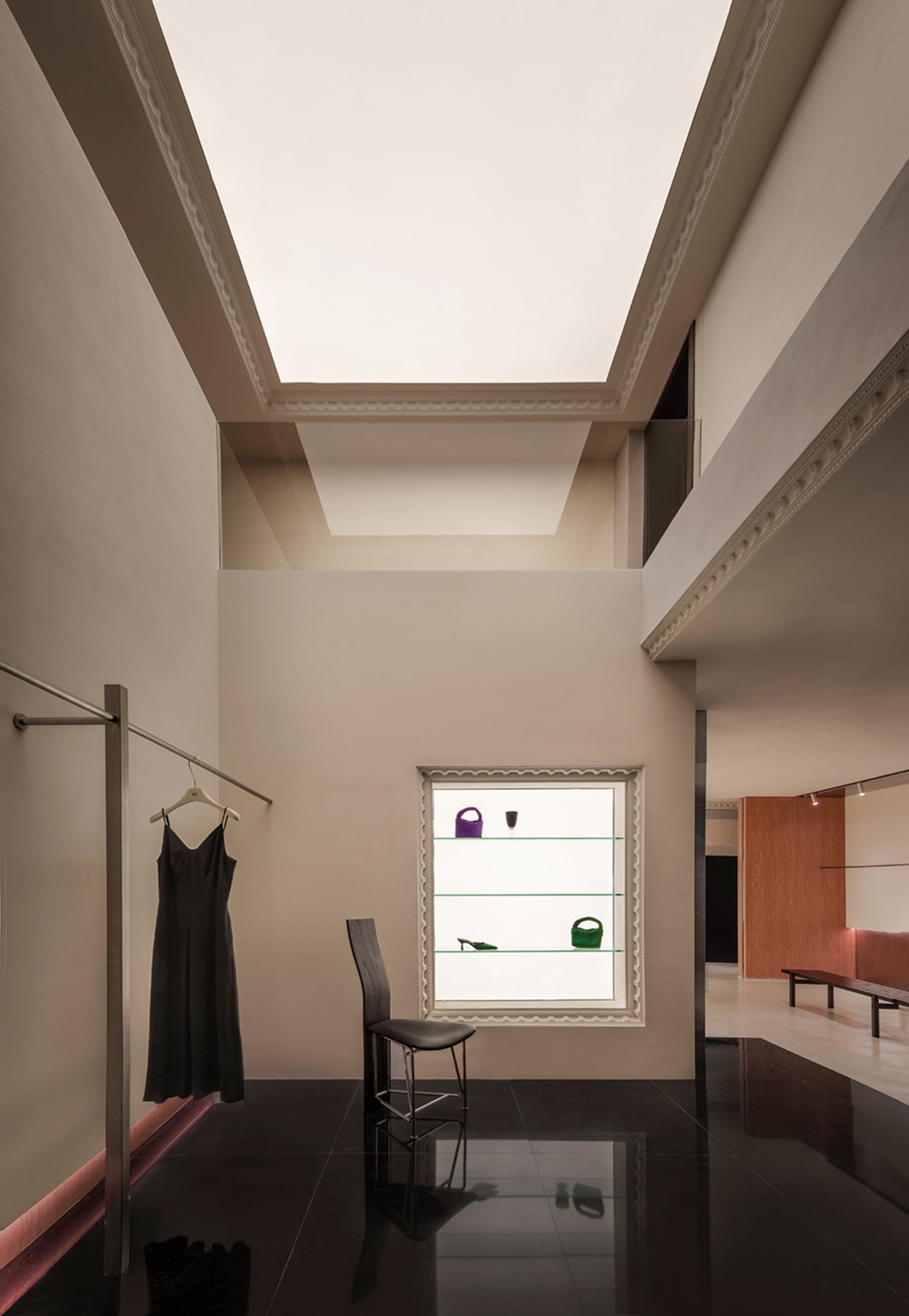 A modern fashion retail store with glass walls and cement flooring.