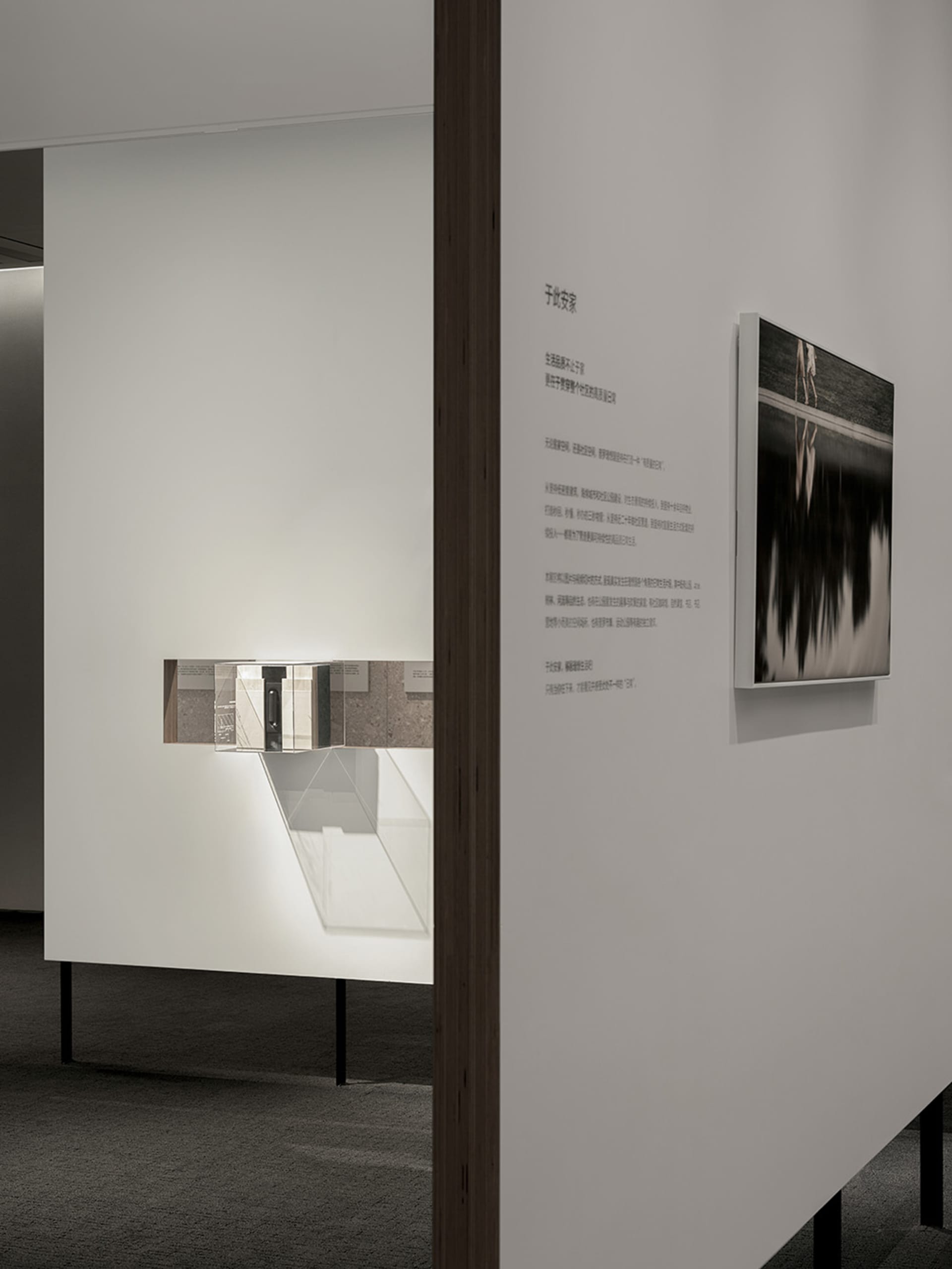 A minimalist installation featuring mixed media elements, including a photo and text.