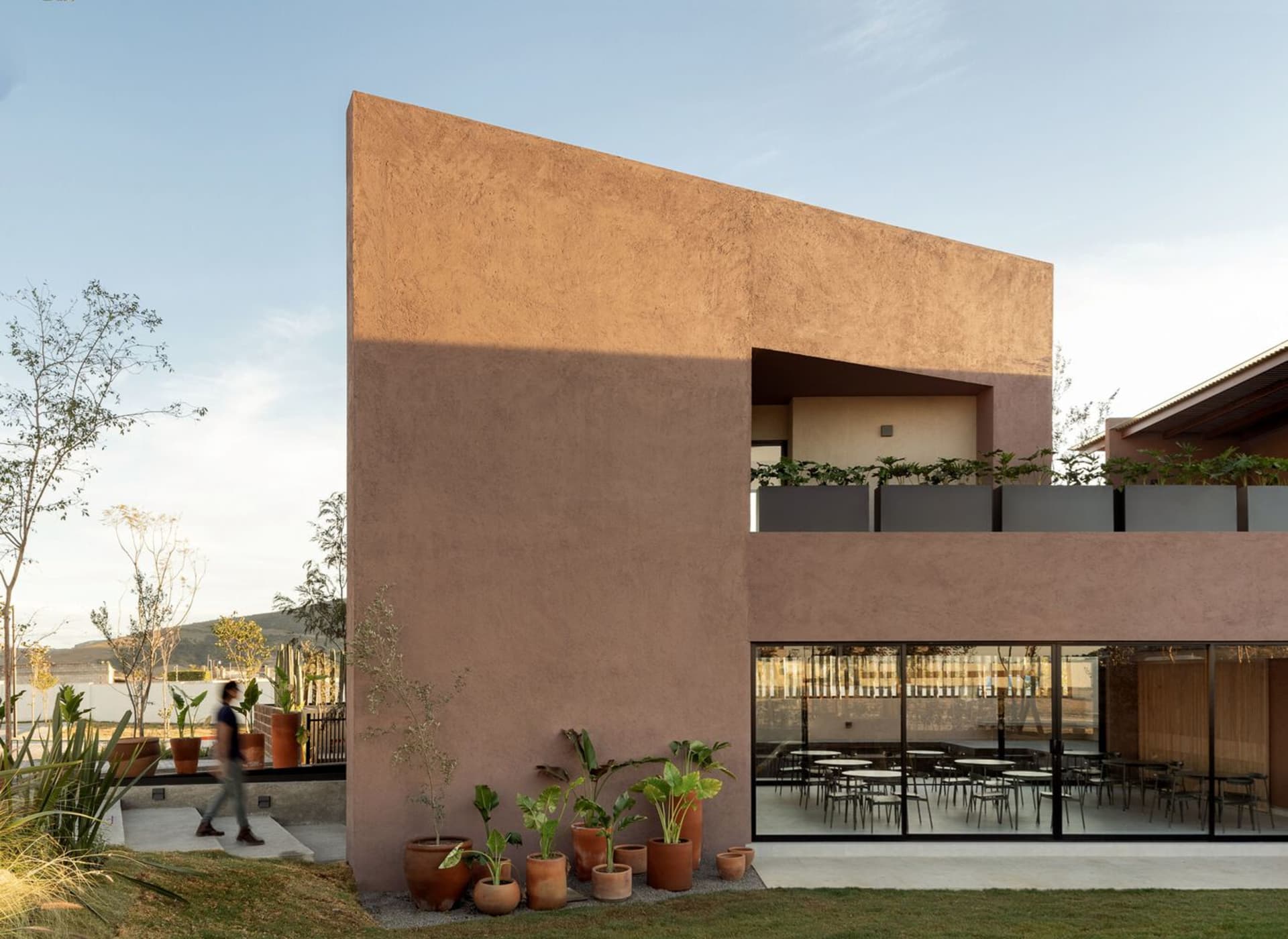 A modern building with a textured concrete facade and a sloped roof.