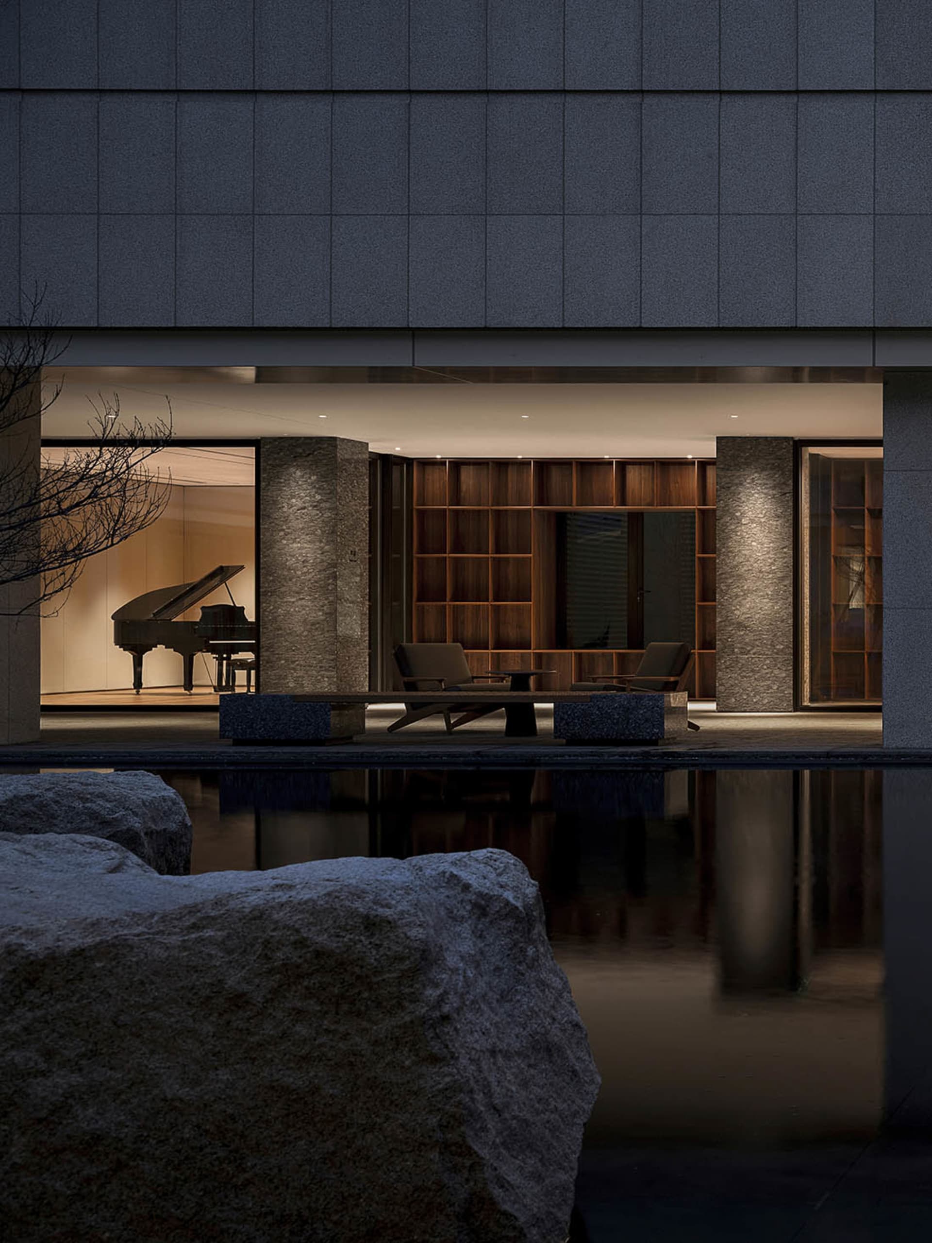 Modern minimalist living room featuring stone, wood, and stainless steel materials.