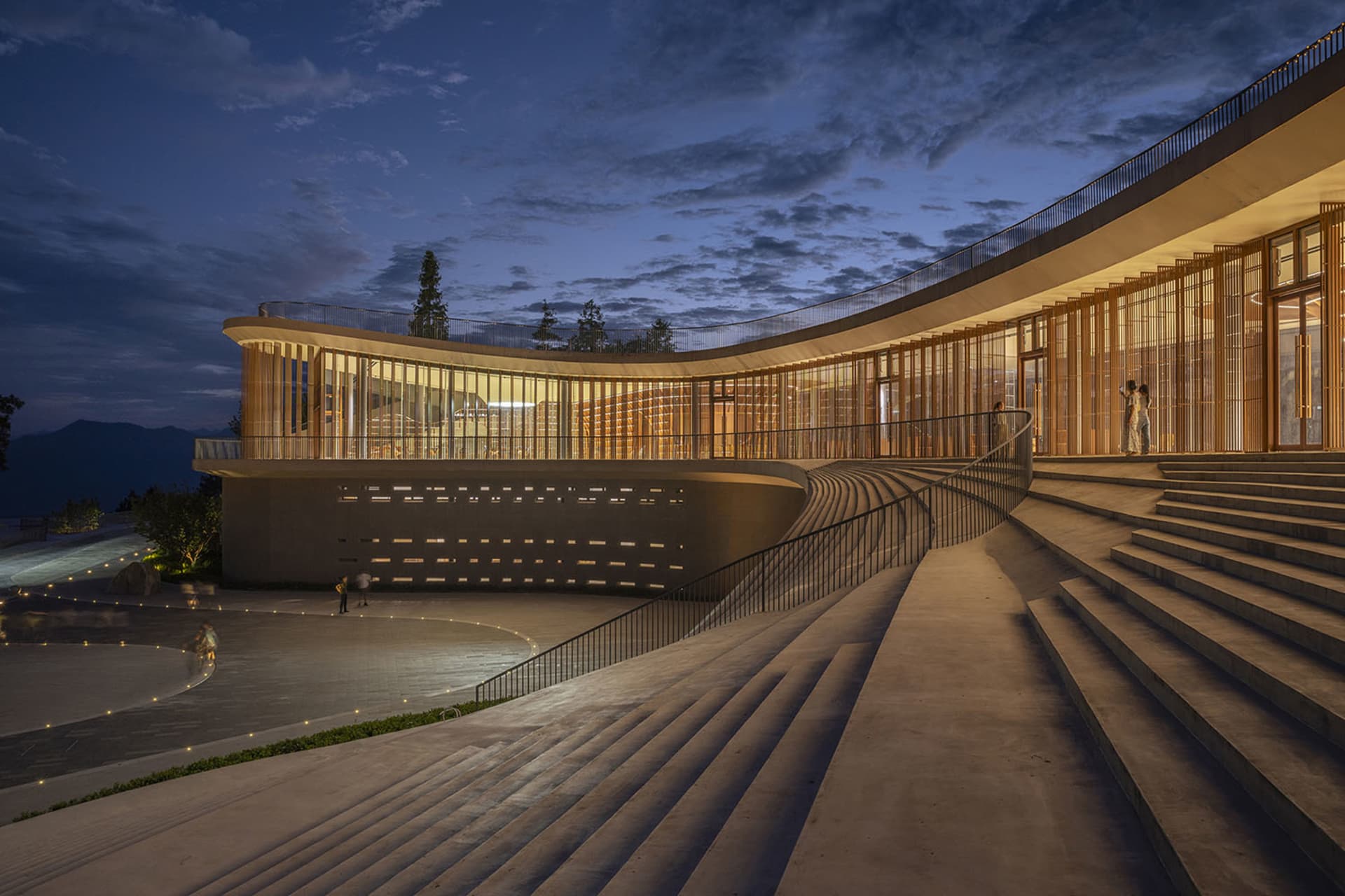 A modern building with curved concrete exterior and glass windows.