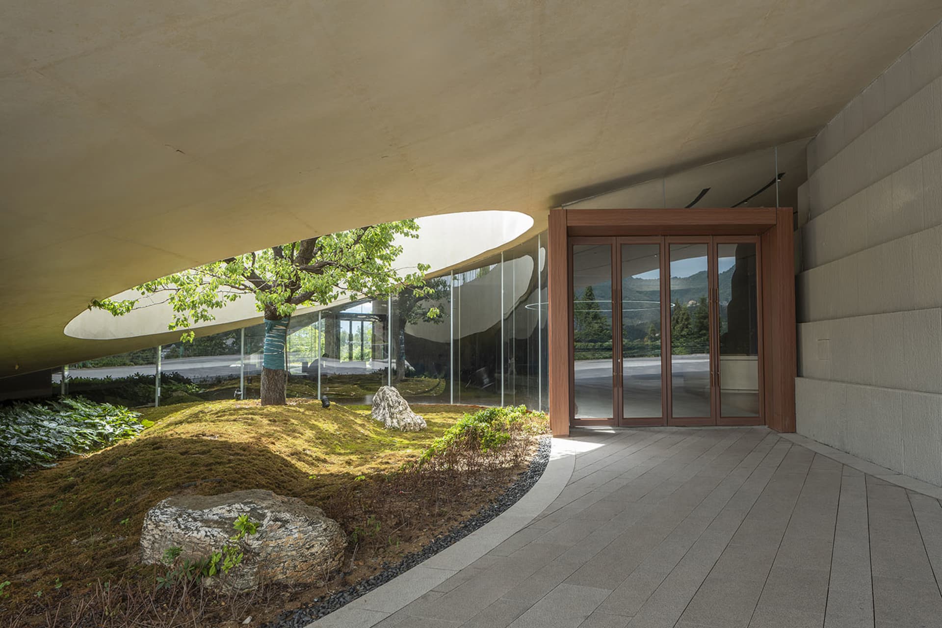 A modern building entrance featuring concrete and glass materials.