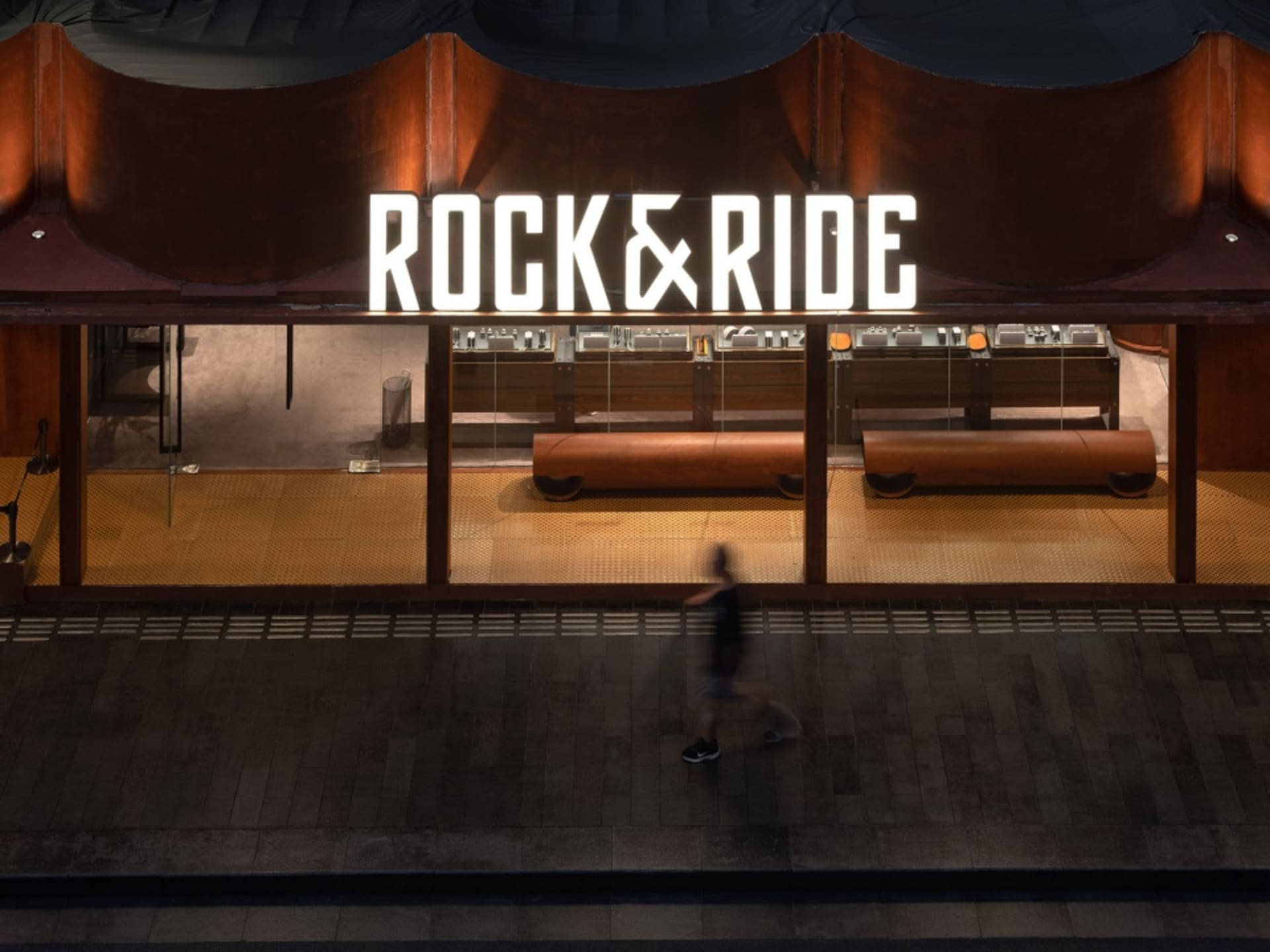 現代工業風零售店面,設有大型金屬招牌,上面顯示「Rock & Ride」店名。