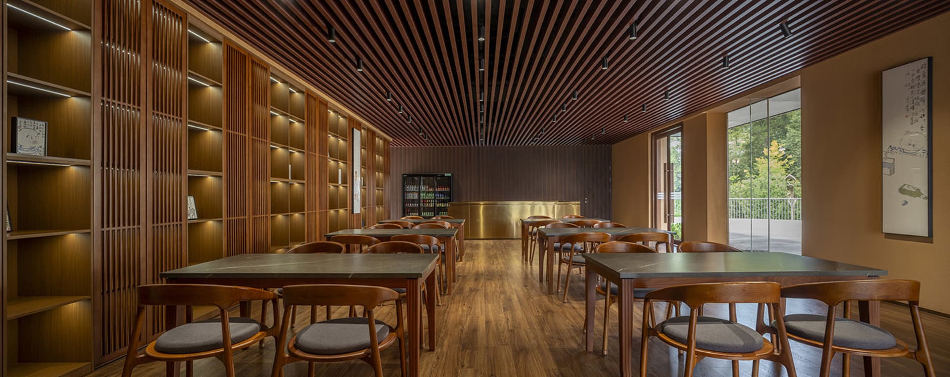寬敞的餐廳室內空間，搭配木質家具與牆面、木條天花板，以及大面窗戶。