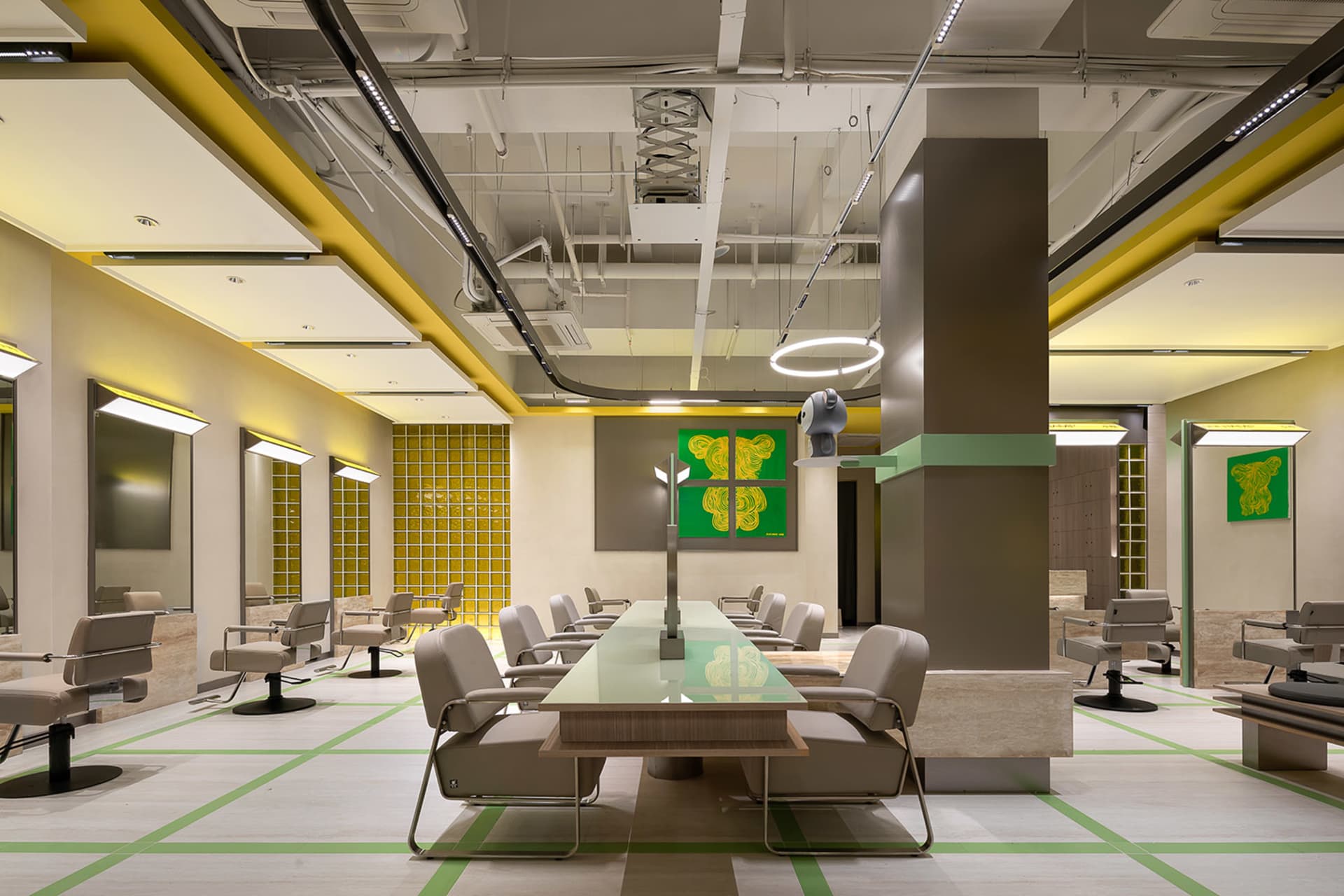 Industrial-style hairstylist salon with concrete walls, glass partitions, and metal accents.
