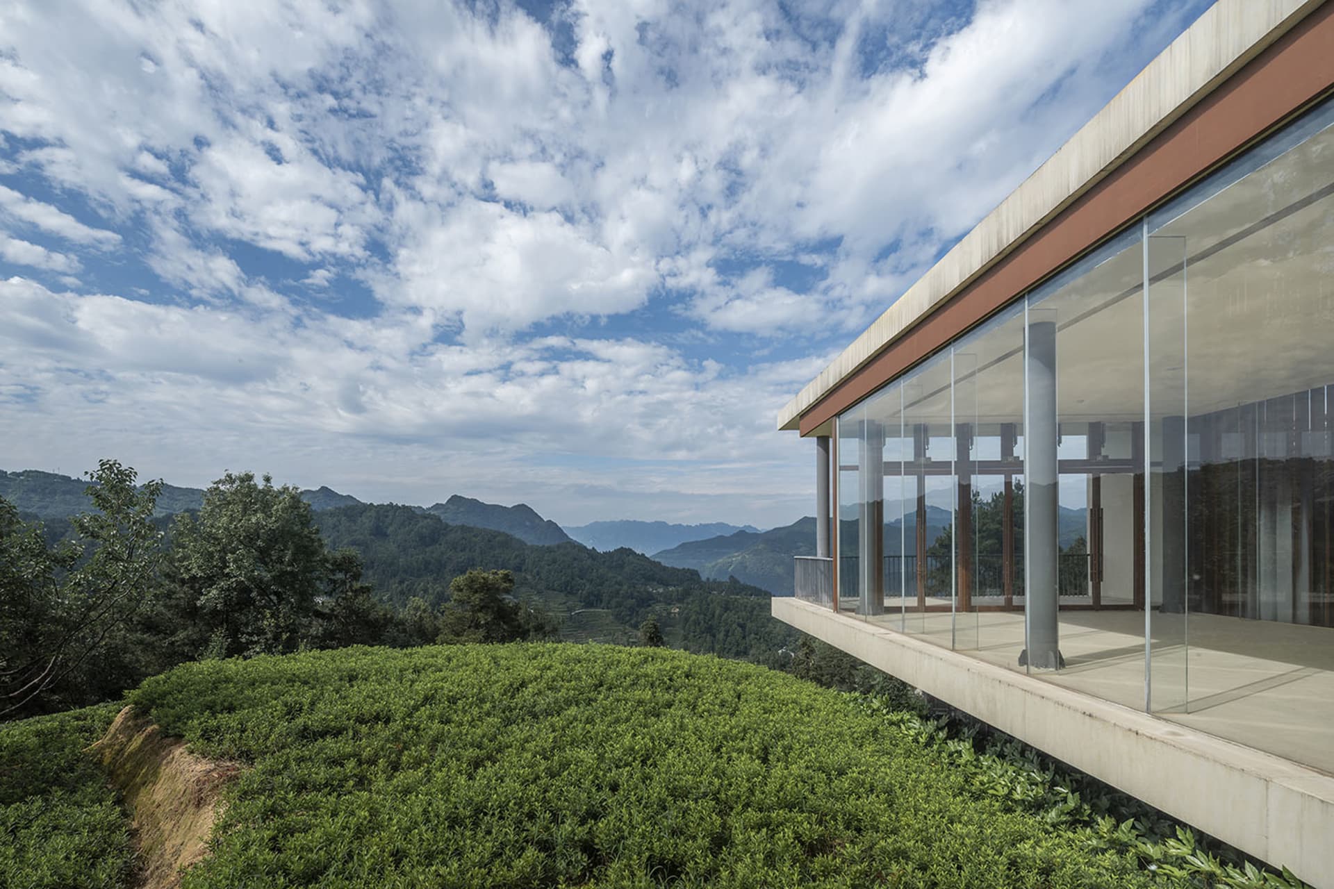 現代住宅露台以玻璃牆圍繞,眺望綠野與山景。