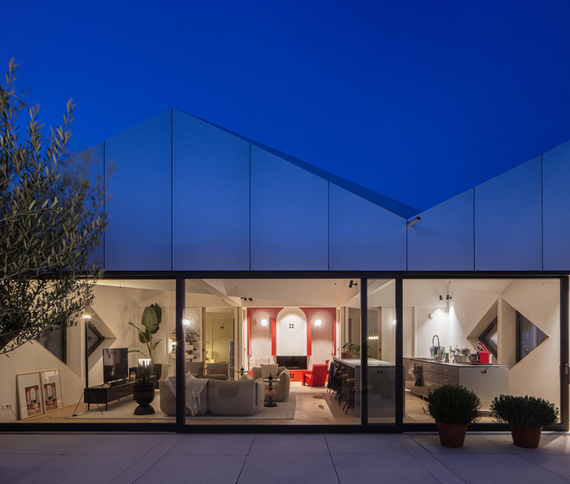 Modern residential interior with large glass walls and a bright, open design.