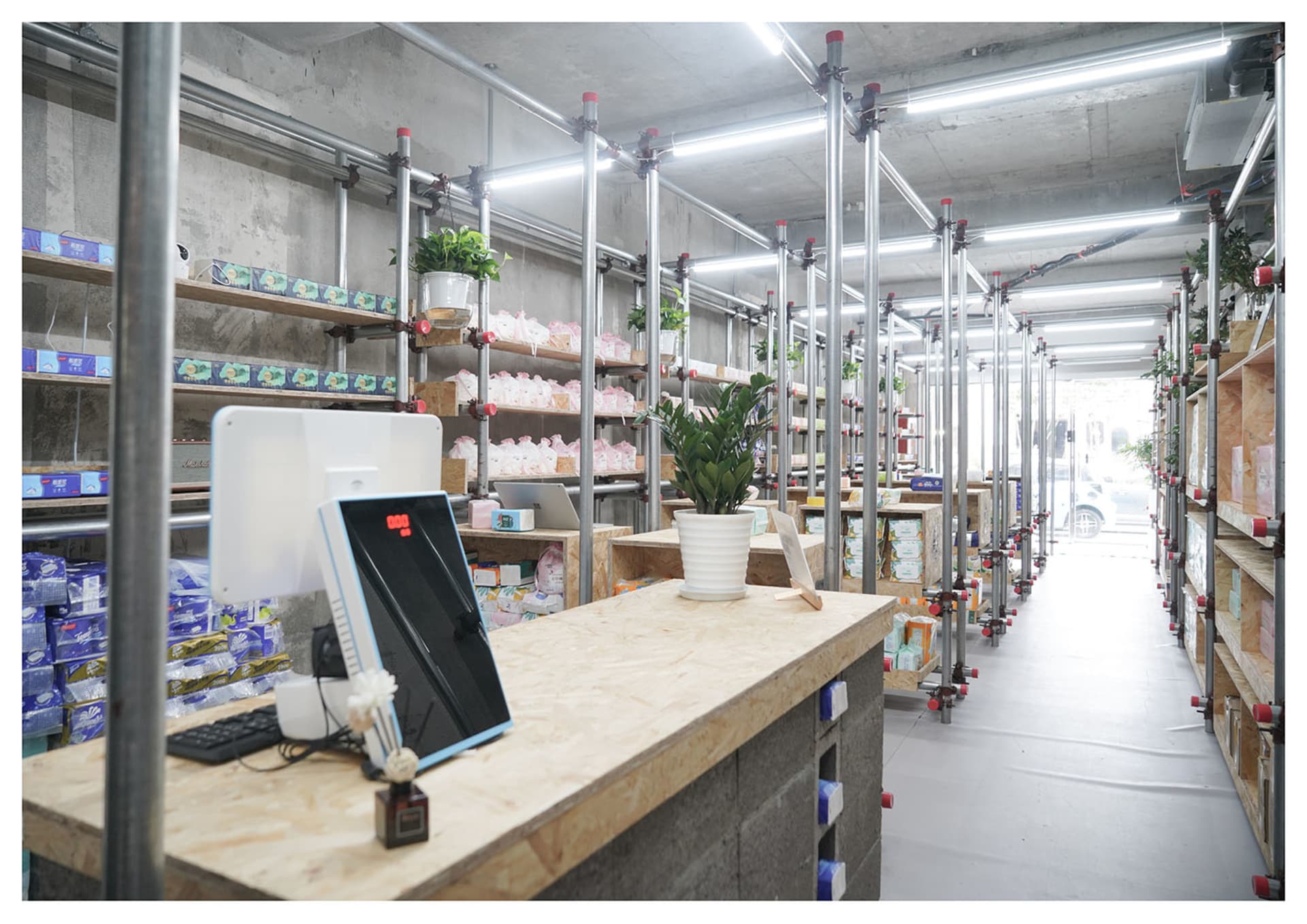 倉庫室內視圖,採用極簡設計,混凝土牆面、金屬橫樑與木製層架。