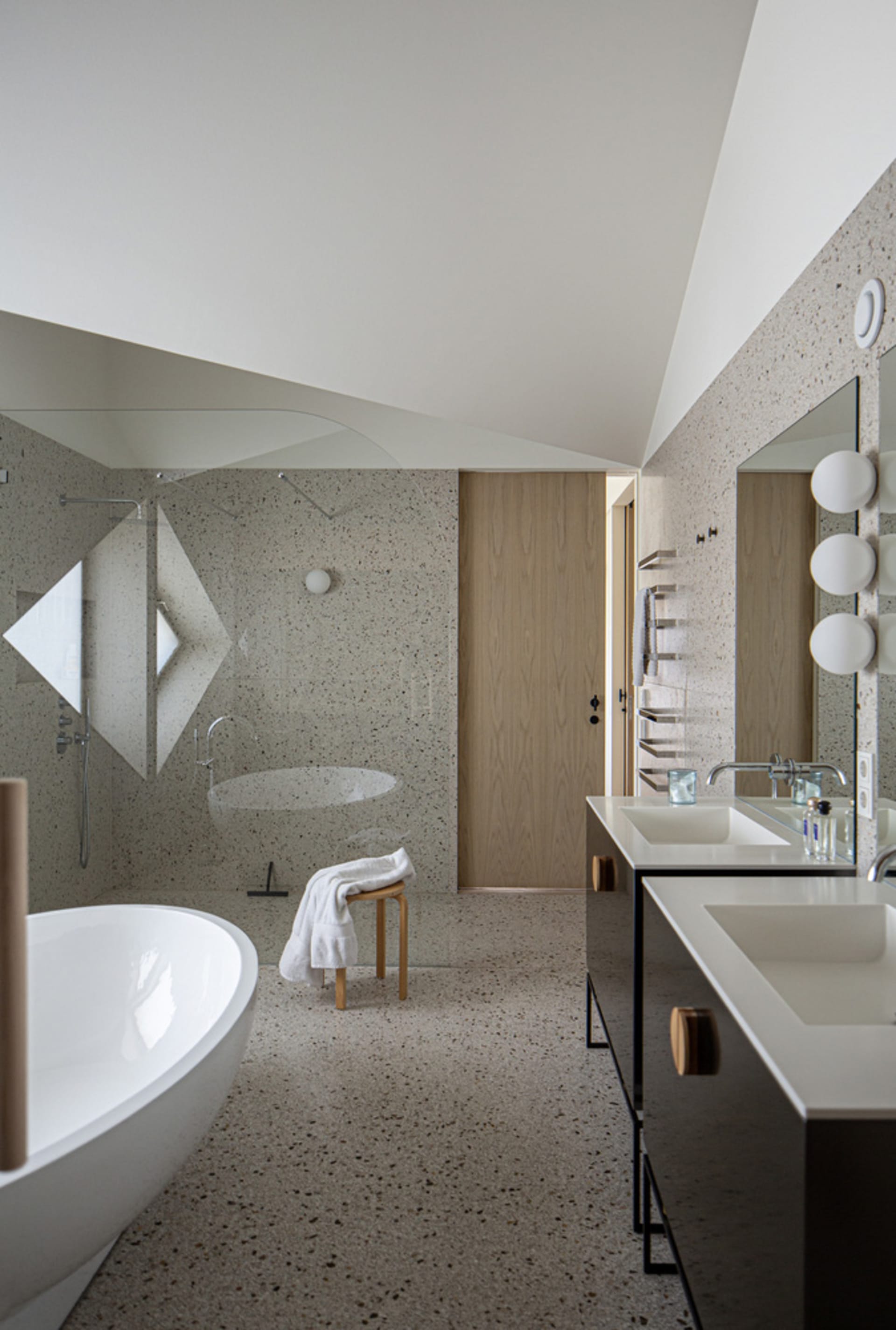 Modern bathroom featuring white tiled walls and floor, a freestanding bathtub, a walk-in shower with a glass door, and a doub