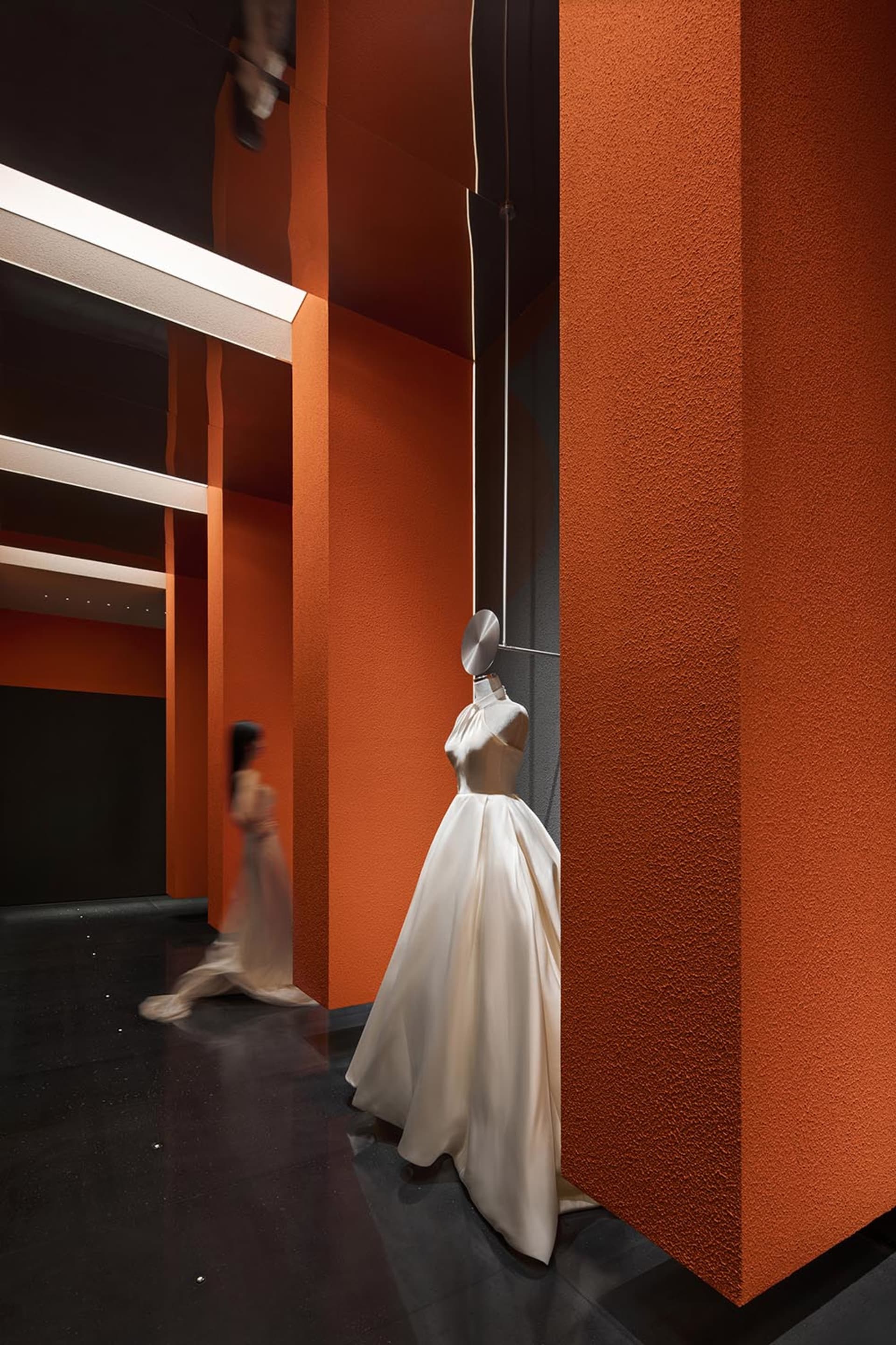 Mannequin wearing a modern, elegant dress in a retail setting.