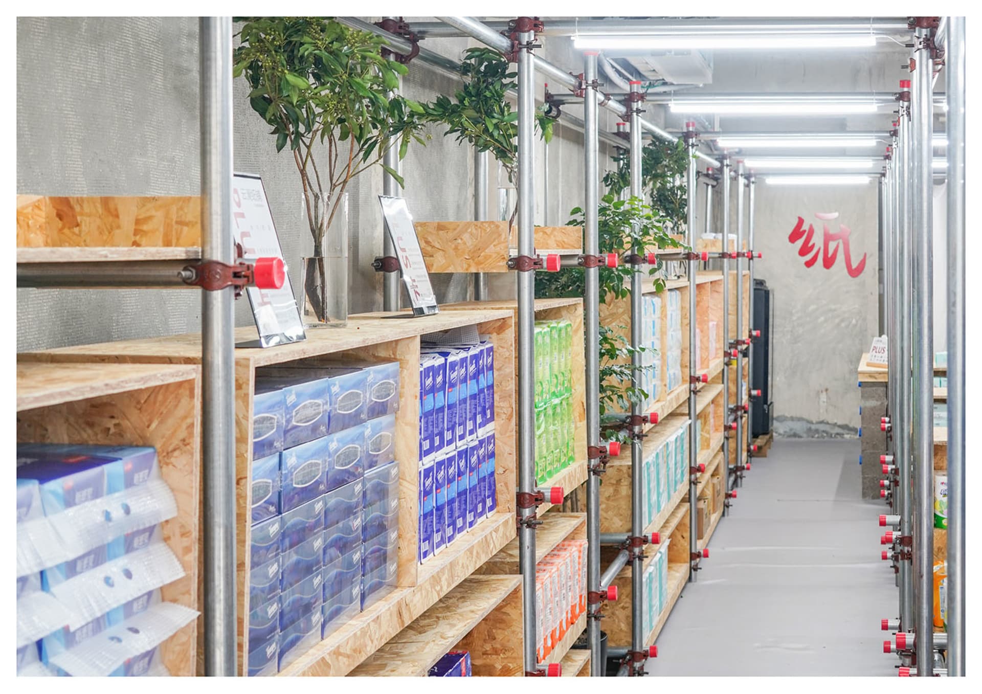Industrial-style wooden storage shelves with greenery and signage in a minimalist interior setting