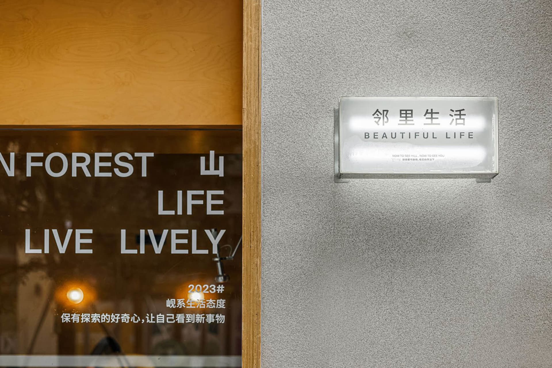 A storefront with a sign reading 'Beautiful Life' in English and '邻里生活' in Chinese, featuring Atlantic Grey Concrete material