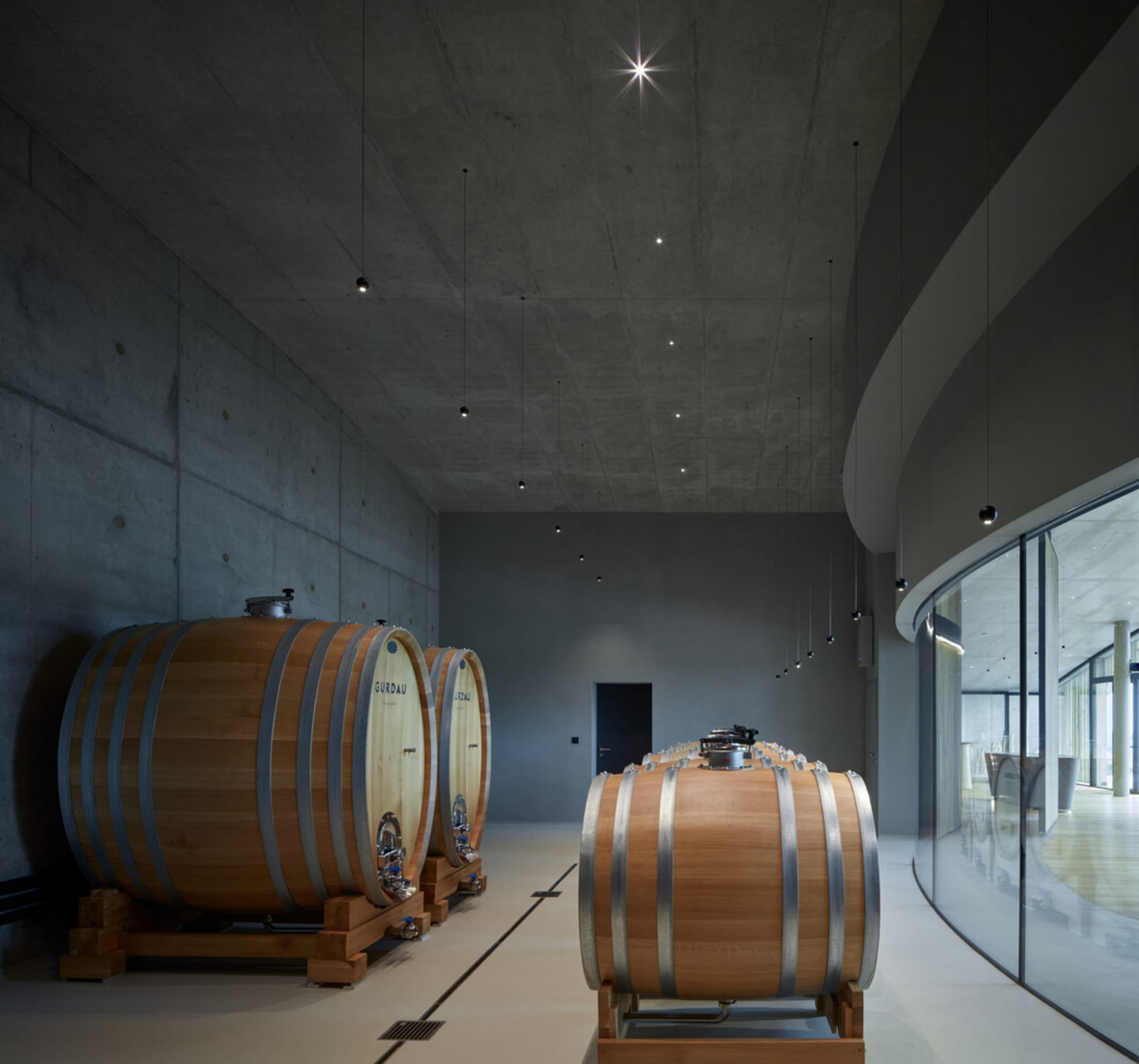 Large wooden wine fermentation tanks in a modern industrial brewery setting.