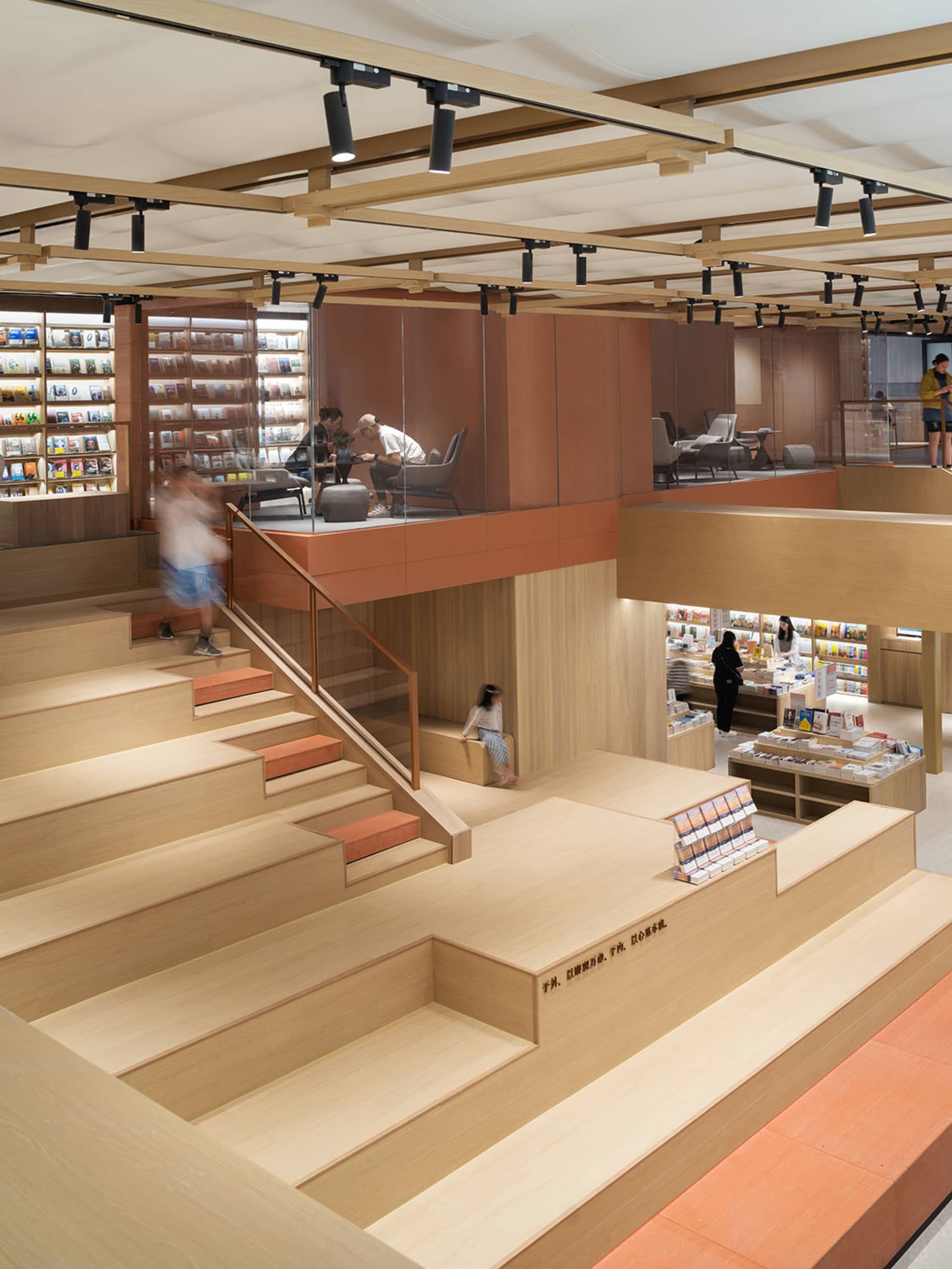現代書店室內空間,配有木製書架、玻璃隔間與座位區。