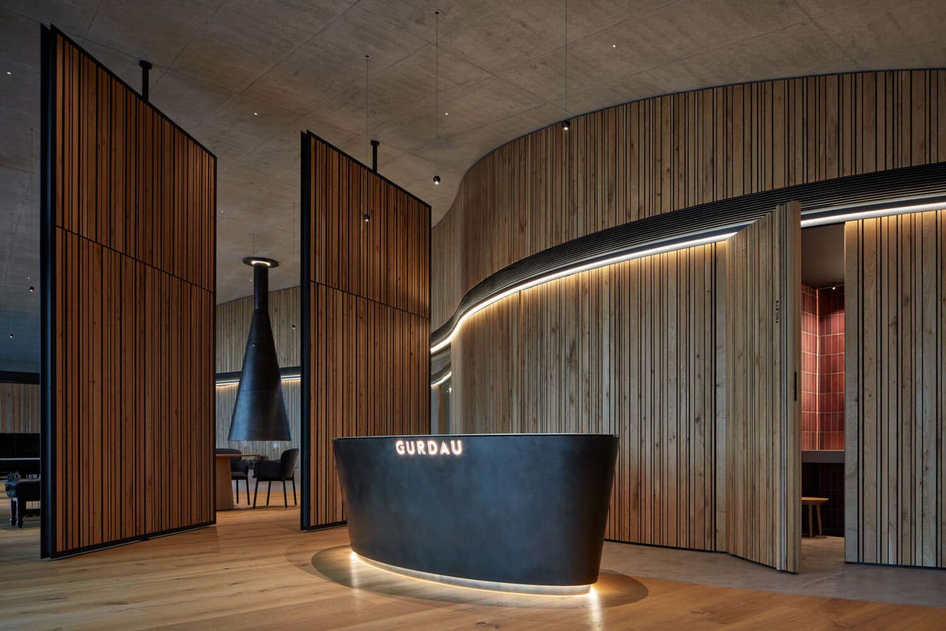 Modern lobby interior with wooden, concrete, and metallic reception desk.