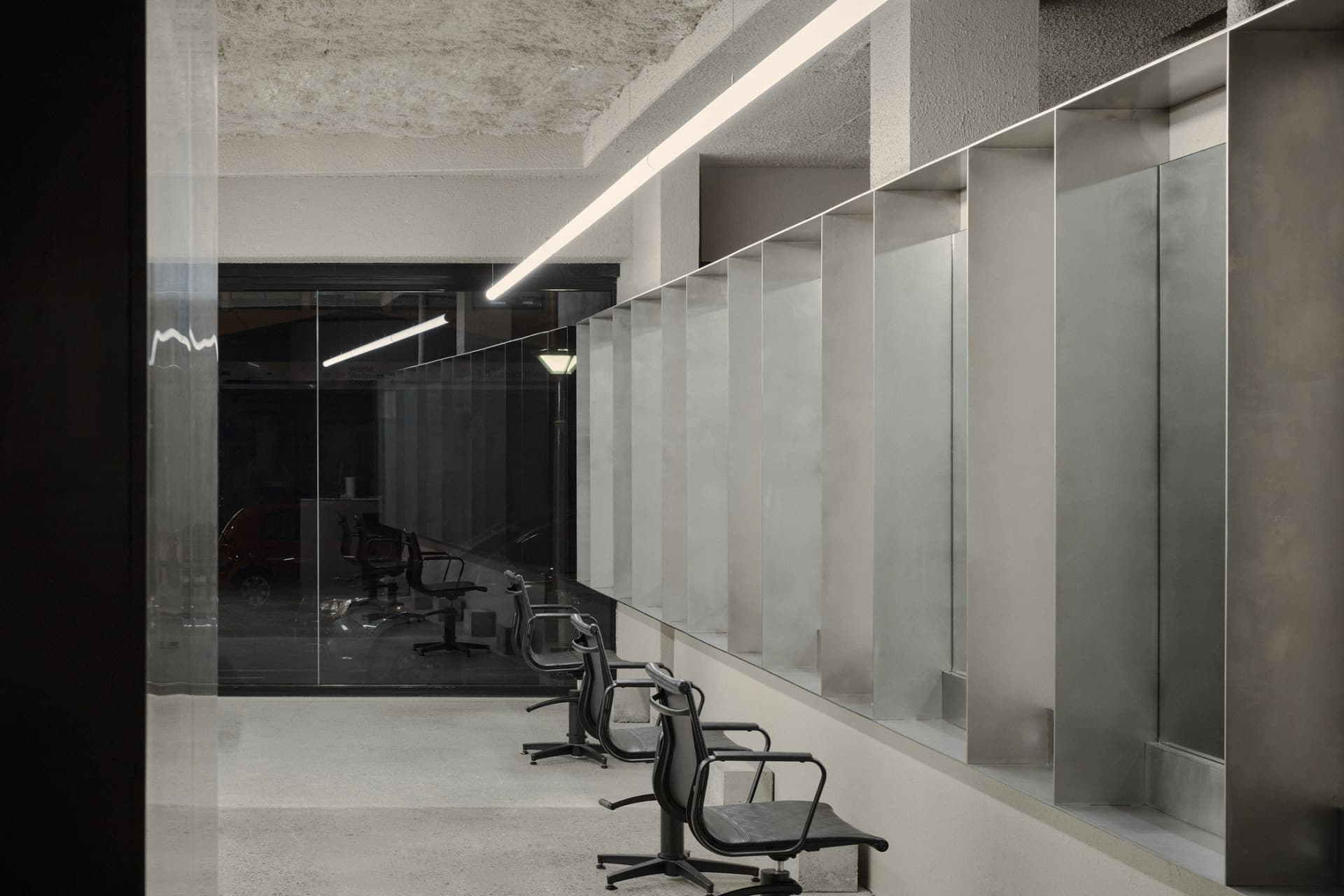 A minimalist office interior featuring industrial-style concrete walls and flooring.