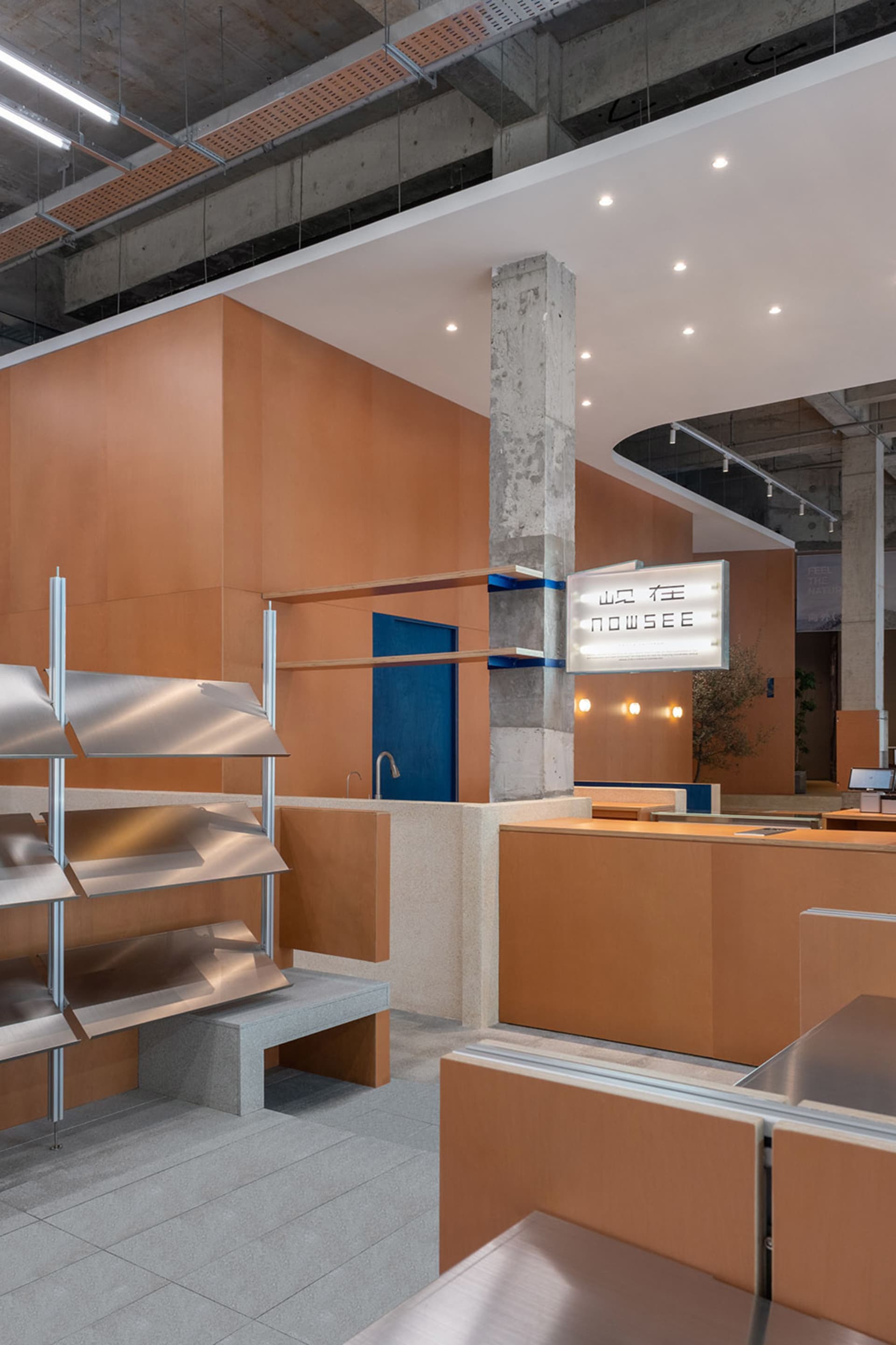 A contemporary food court featuring a modern industrial design with metal, wood, and concrete materials.