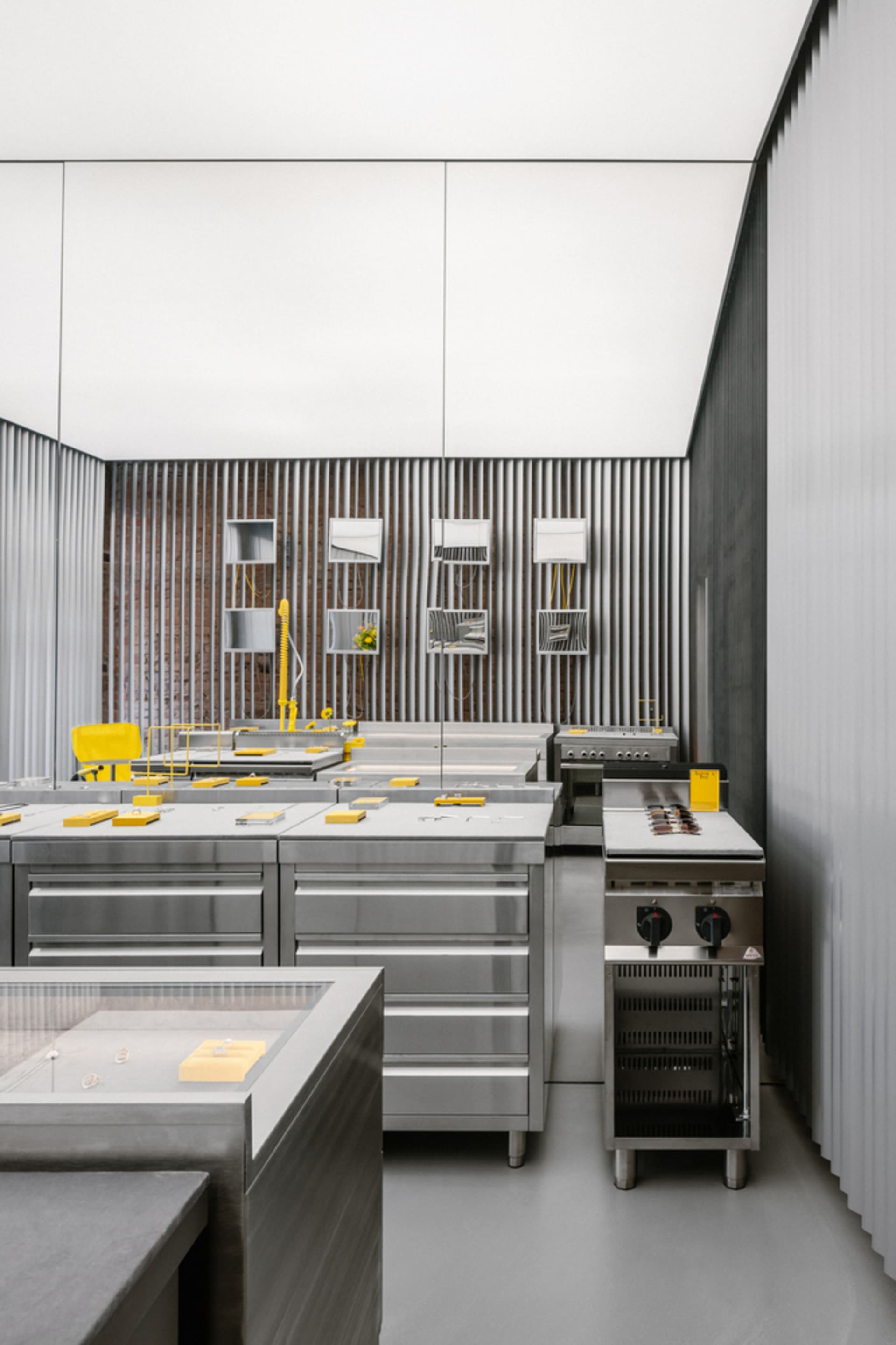 A sleek and contemporary commercial kitchen with stainless steel countertops and concrete accents.