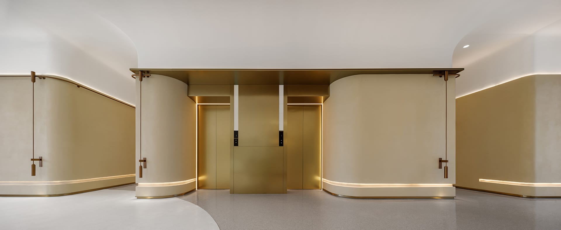 Modern lobby with gold metallic elevator paneling and curved walls