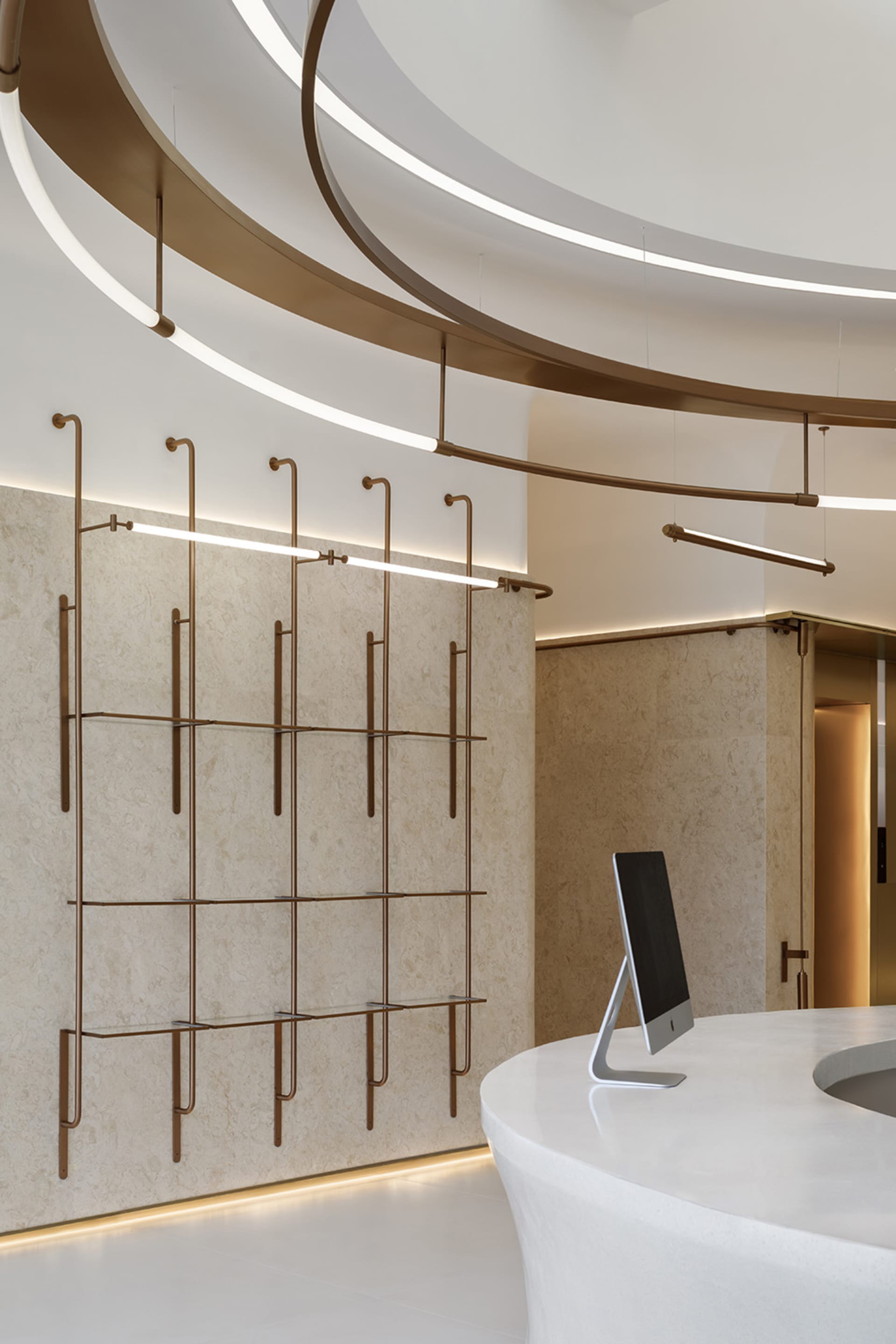 A modern reception desk space featuring metallic shelving and a marble countertop