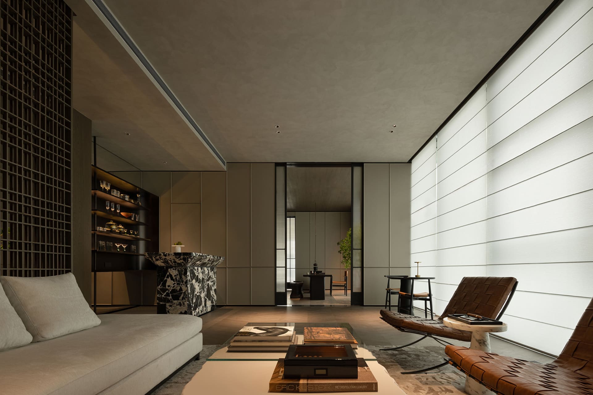 The modern living room features minimalist design with concrete furniture and floor, along with a sleek sofa and coffee table