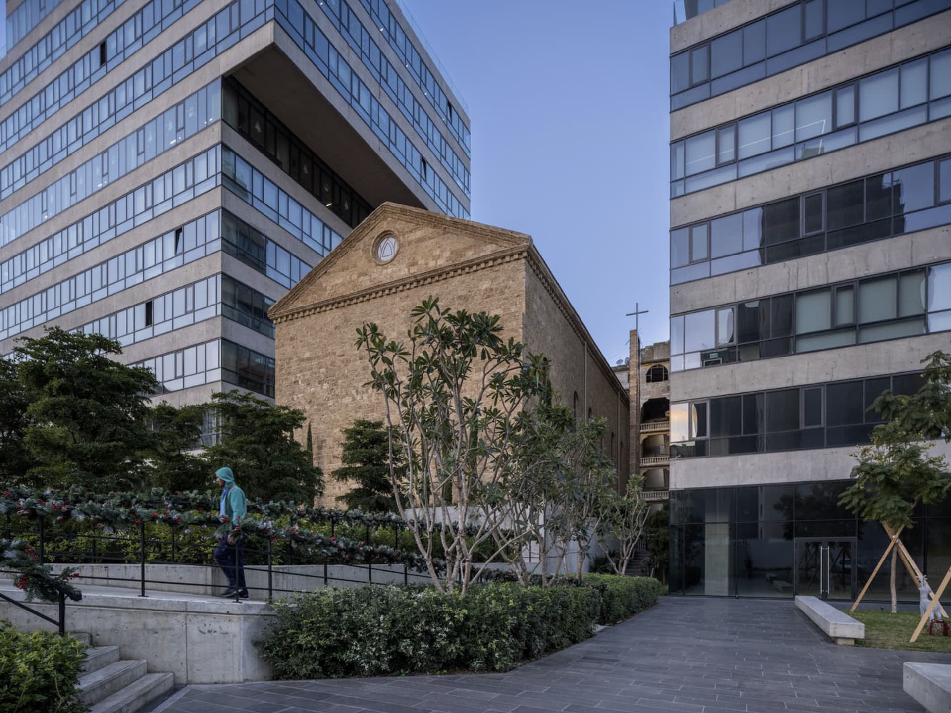 A modern office building with brick and concrete exterior and glass windows, viewed from an outdoor perspective showing the s