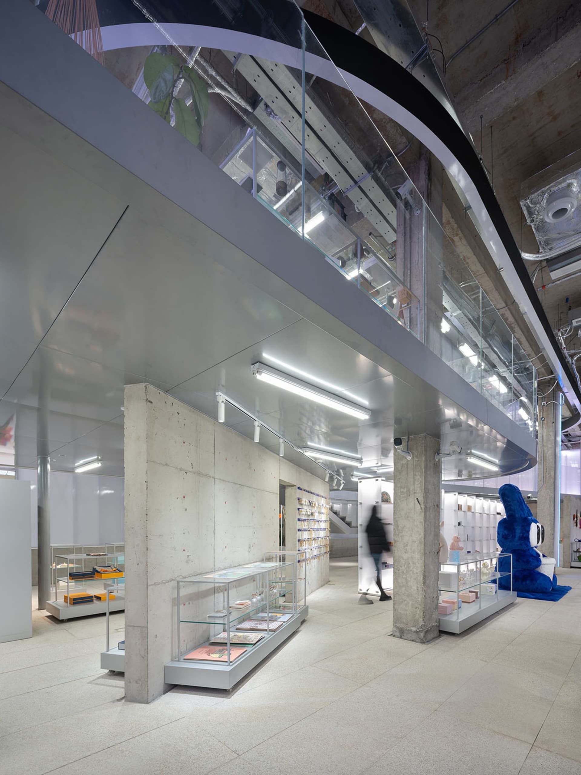 A modern retail store with concrete walls and glass displays.