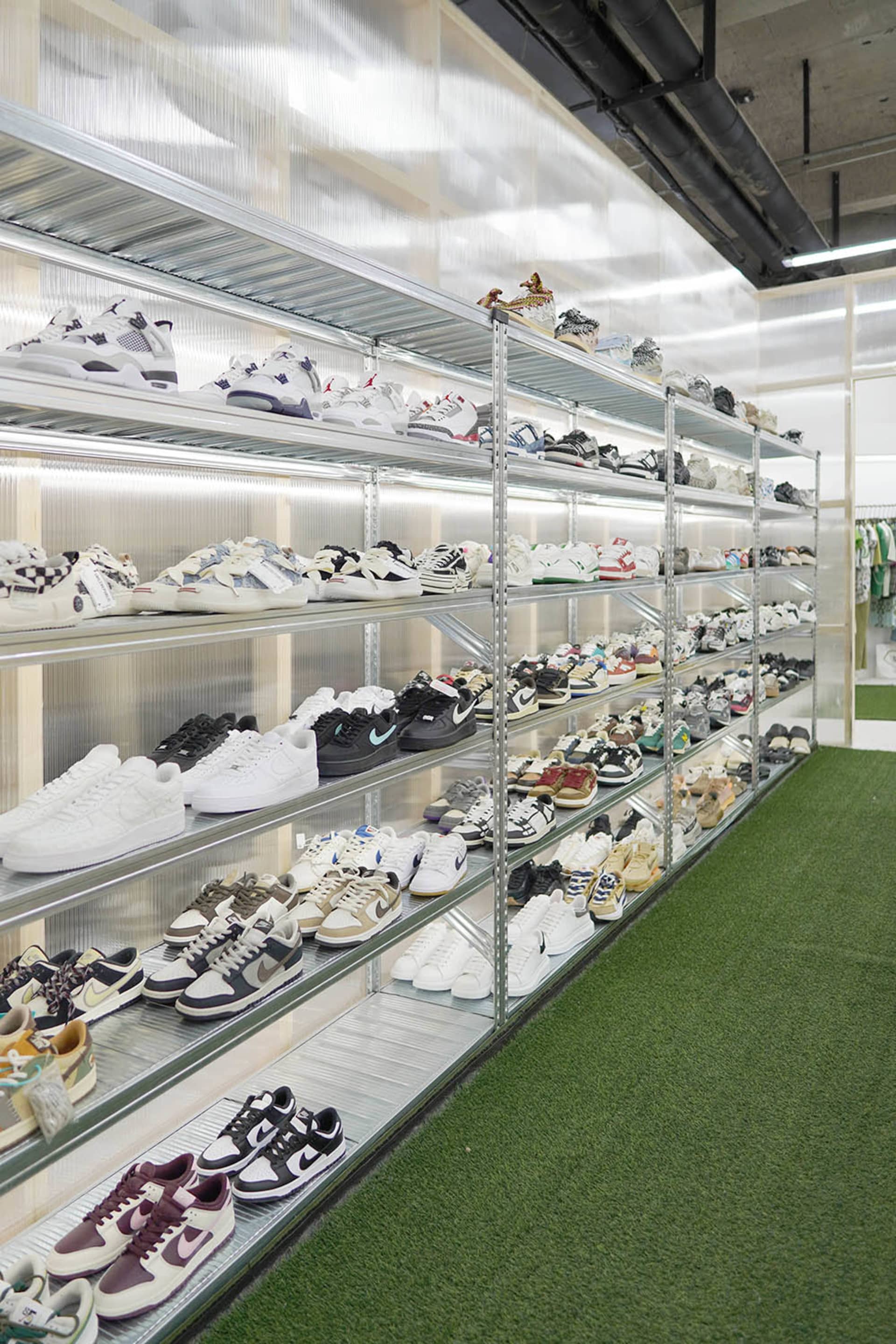 Shoe store with metal shelves, glass walls, and various shoes displayed.