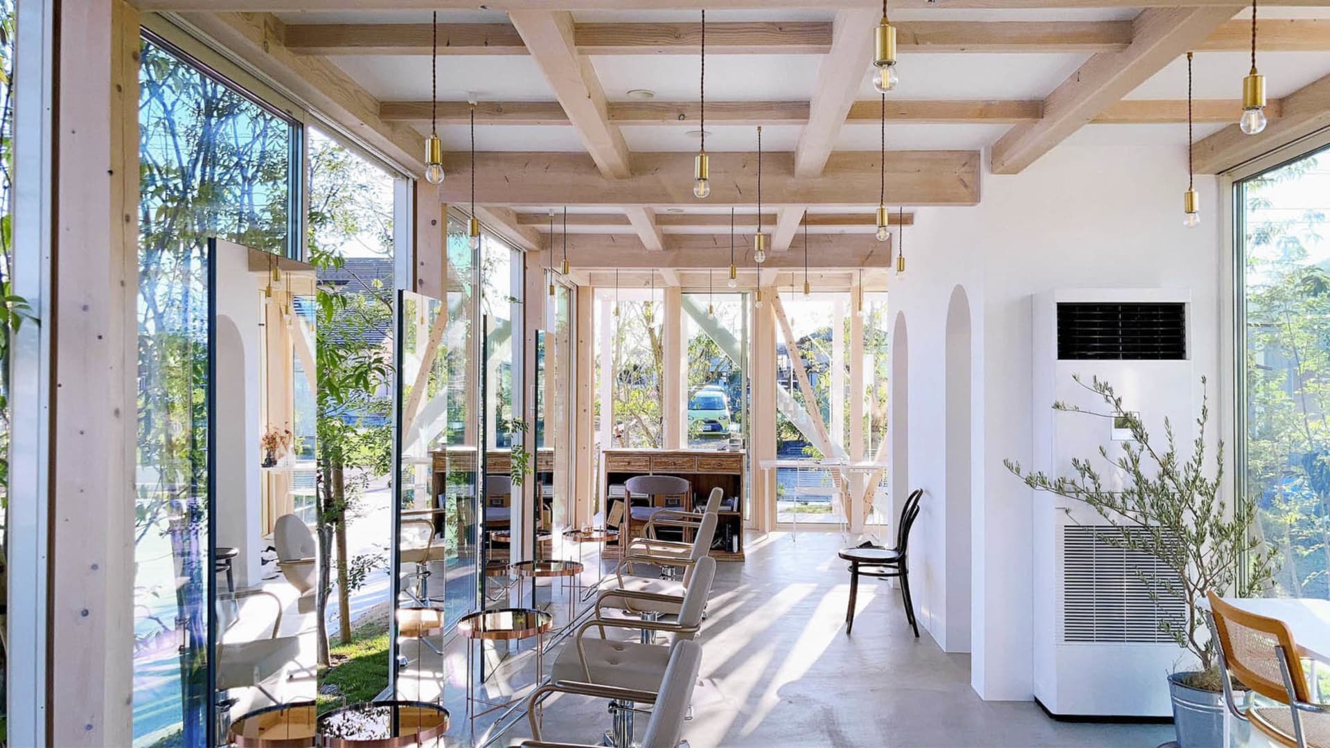 A modern coffee shop featuring glass walls and white walls.