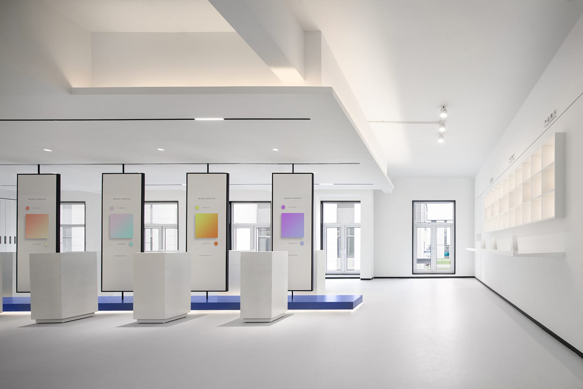 極簡空間擁有白色牆面與地板，展示藝術品於白色基座上，並設有白色展示架牆。