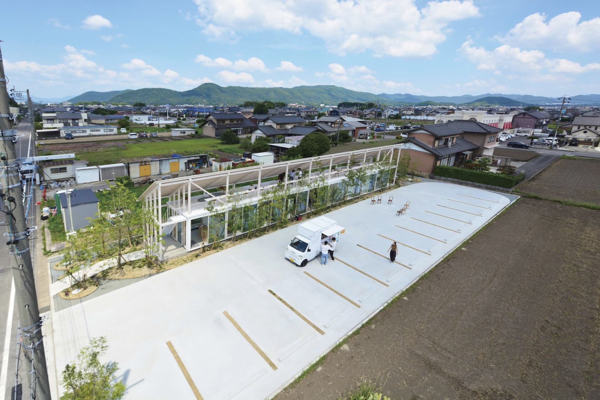 An aerial view of a modern public space featuring glass walls and a concrete floor.