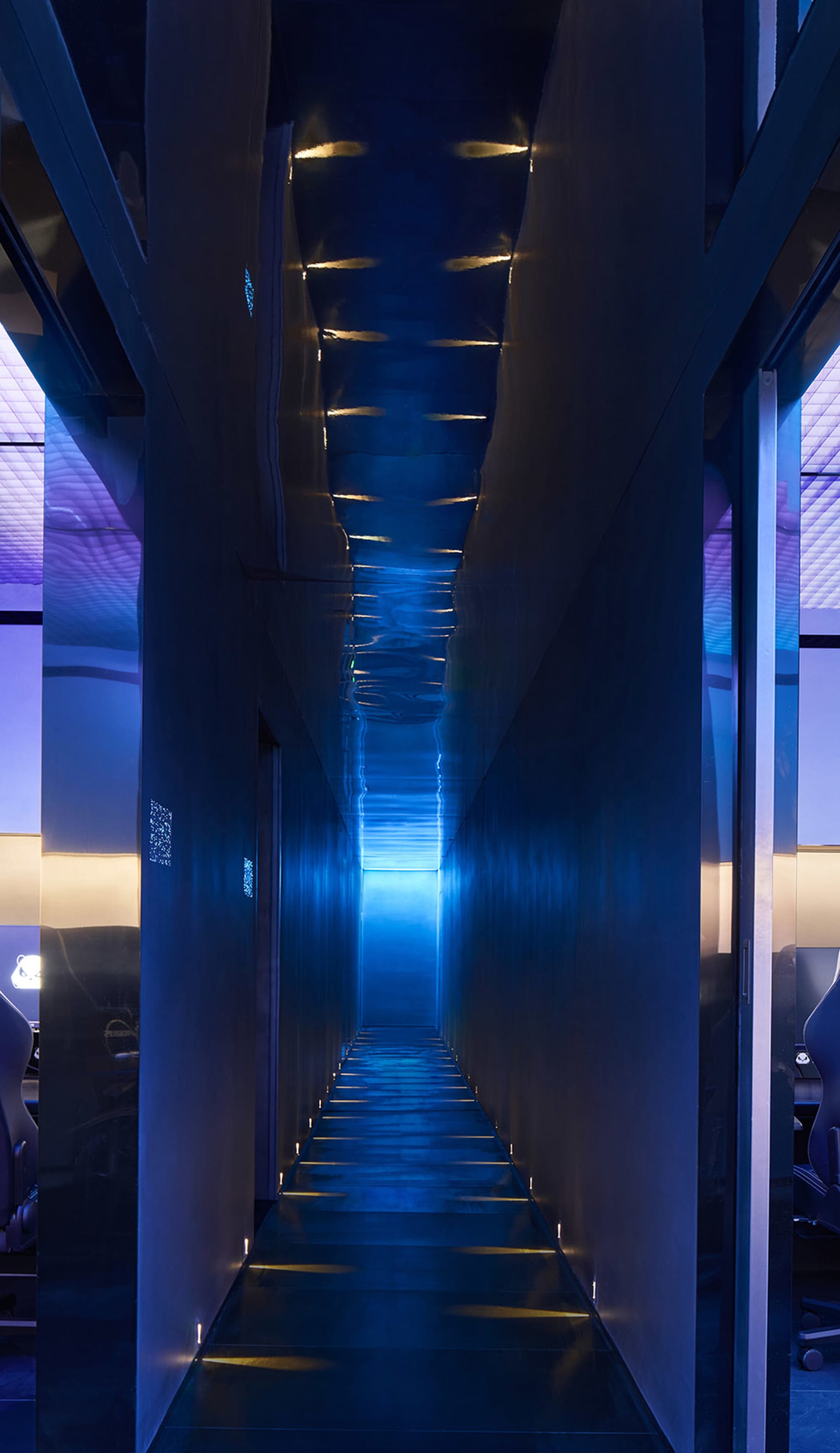 A sleek, modern hallway with glass walls and metallic accents.