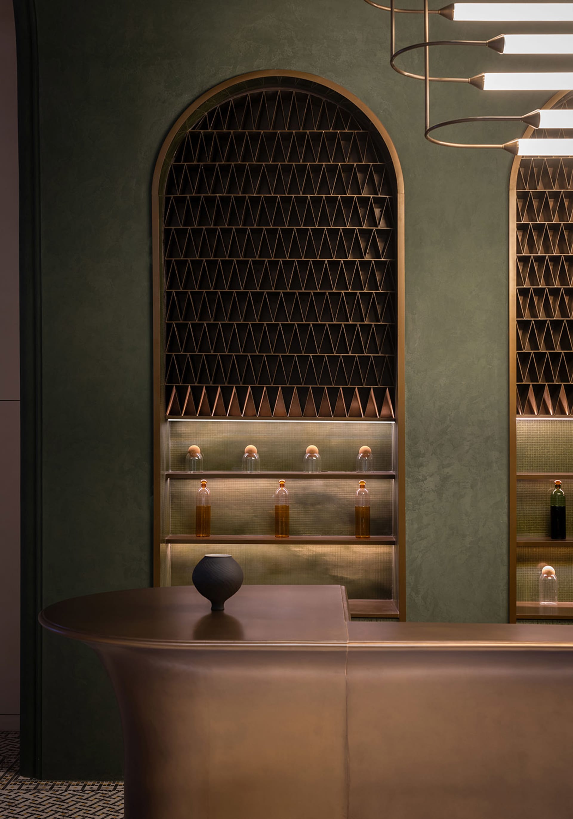 Modern bar interior with matte black counter, leather accents, metal shelves, and geometric shelving.