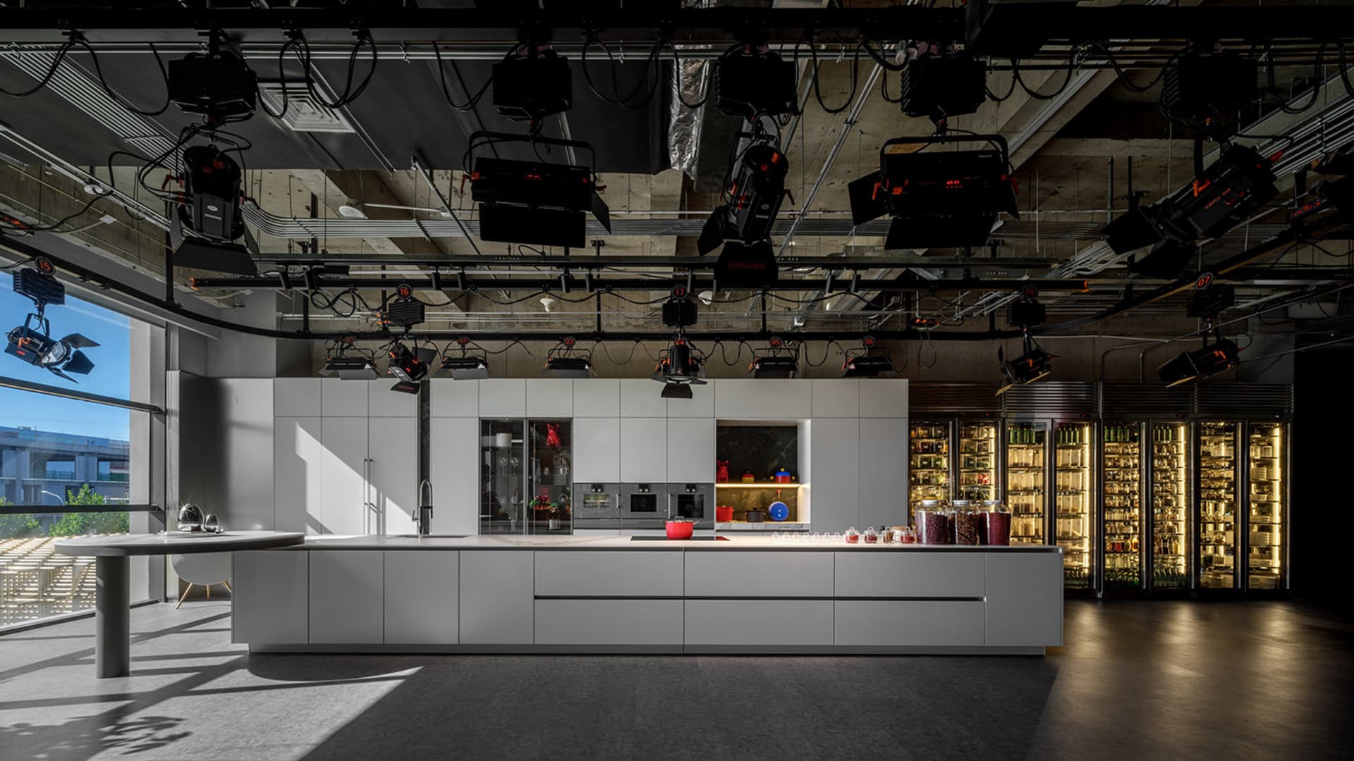 Modern kitchen featuring white concrete countertops, minimalist design, and industrial lighting.