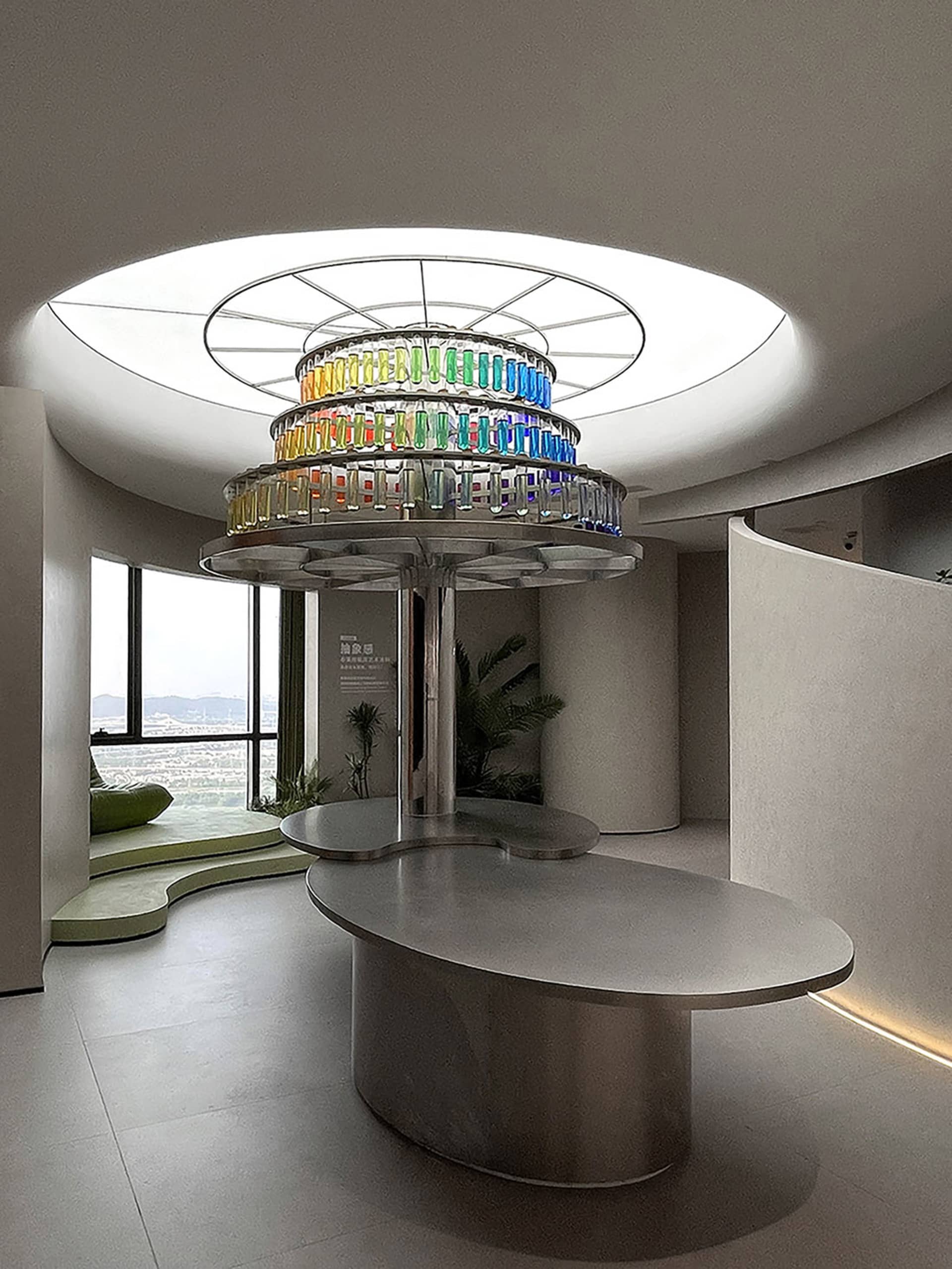 A circular art installation featuring colorful glass bottles in a modern lobby setting.