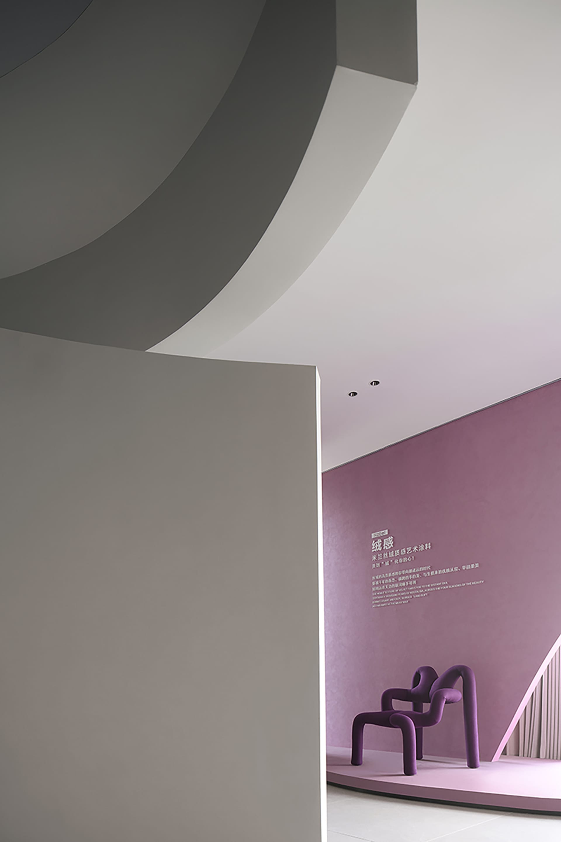 A modern, purple-themed room featuring unique, sculptural furniture covered in velvet upholstery.