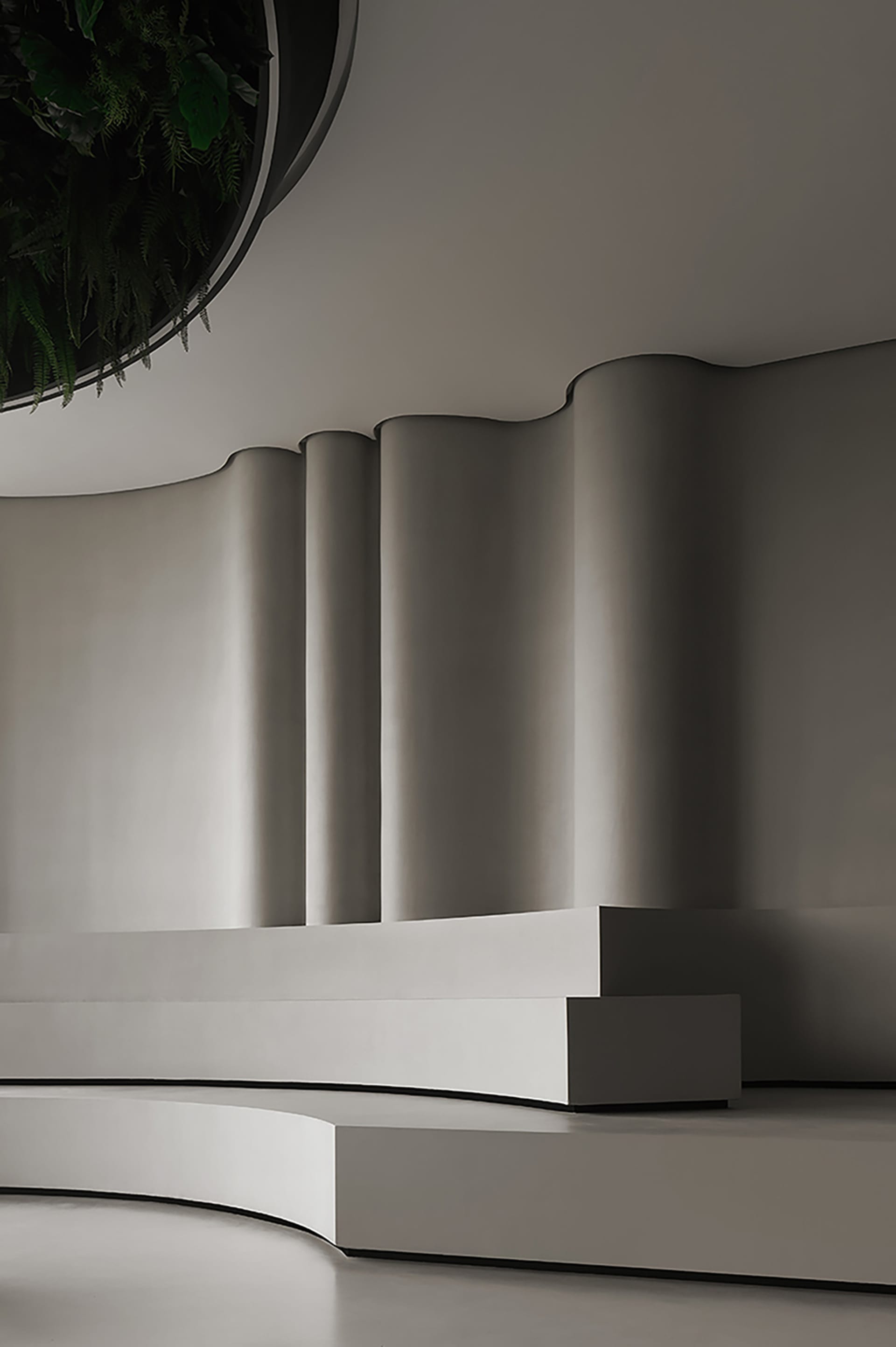 A modern lobby interior with a curved, concrete bench and wall.
