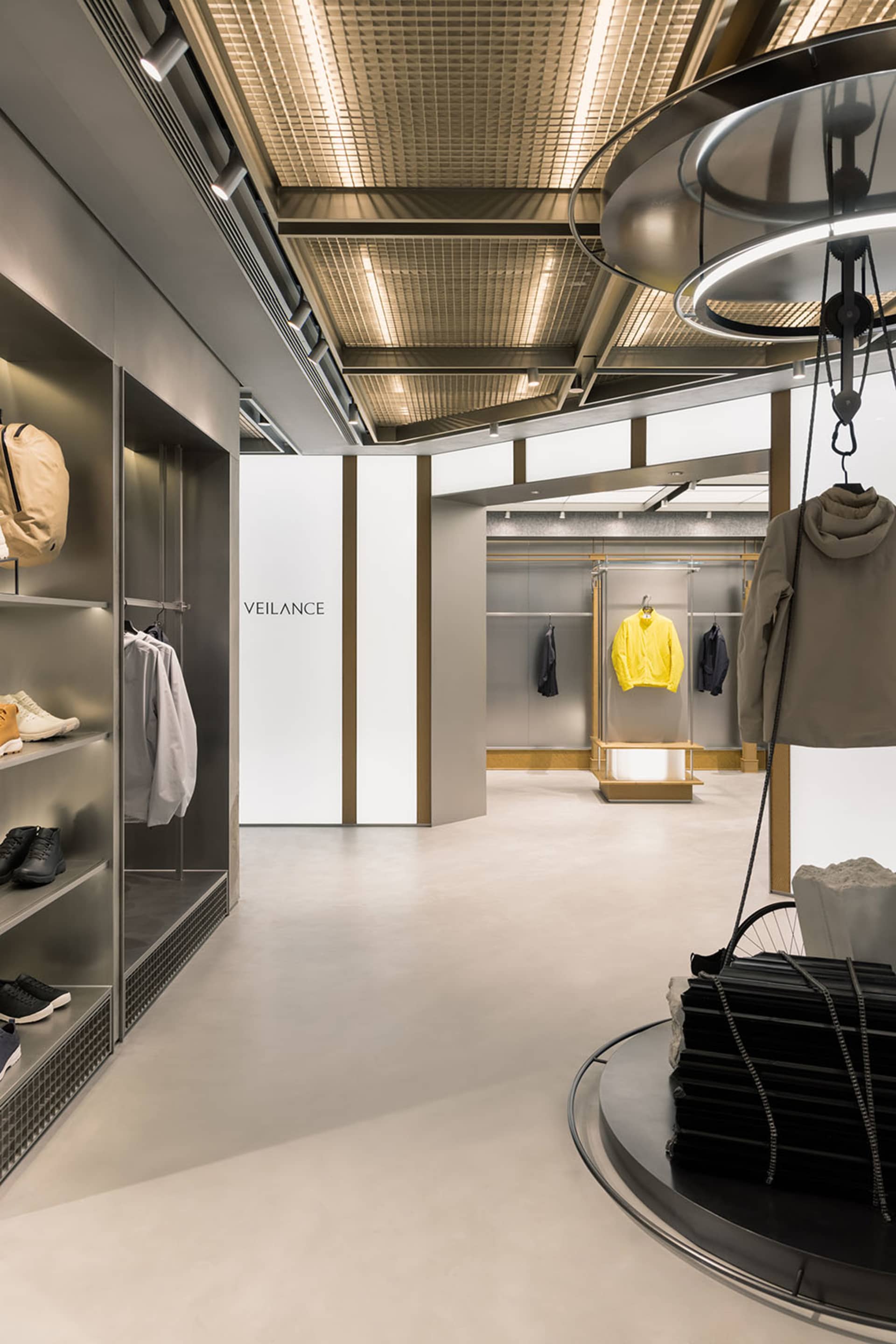 Modern retail store with metallic accents, glass displays, and concrete floors.