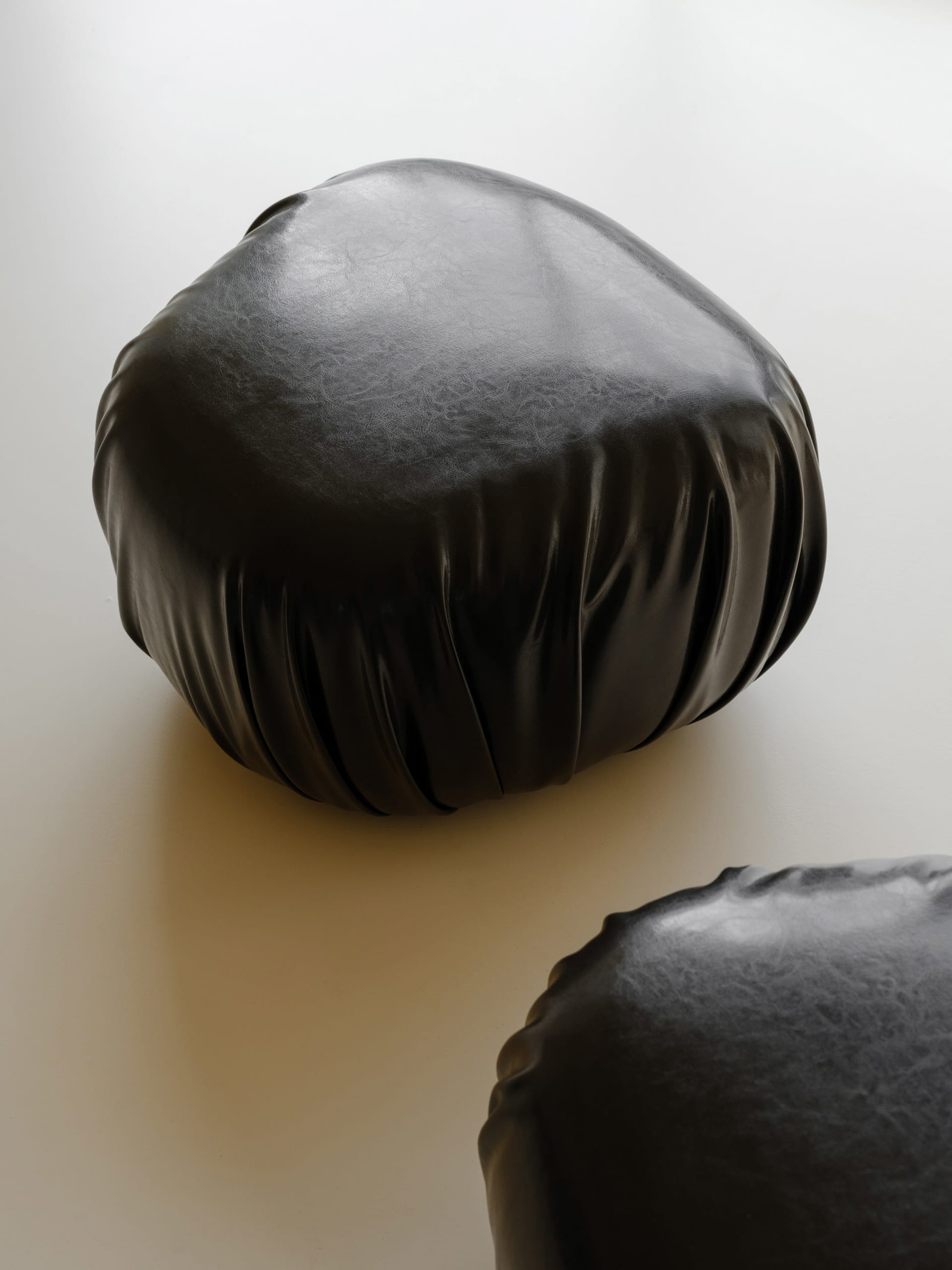 A minimalist, black, fabric-covered object