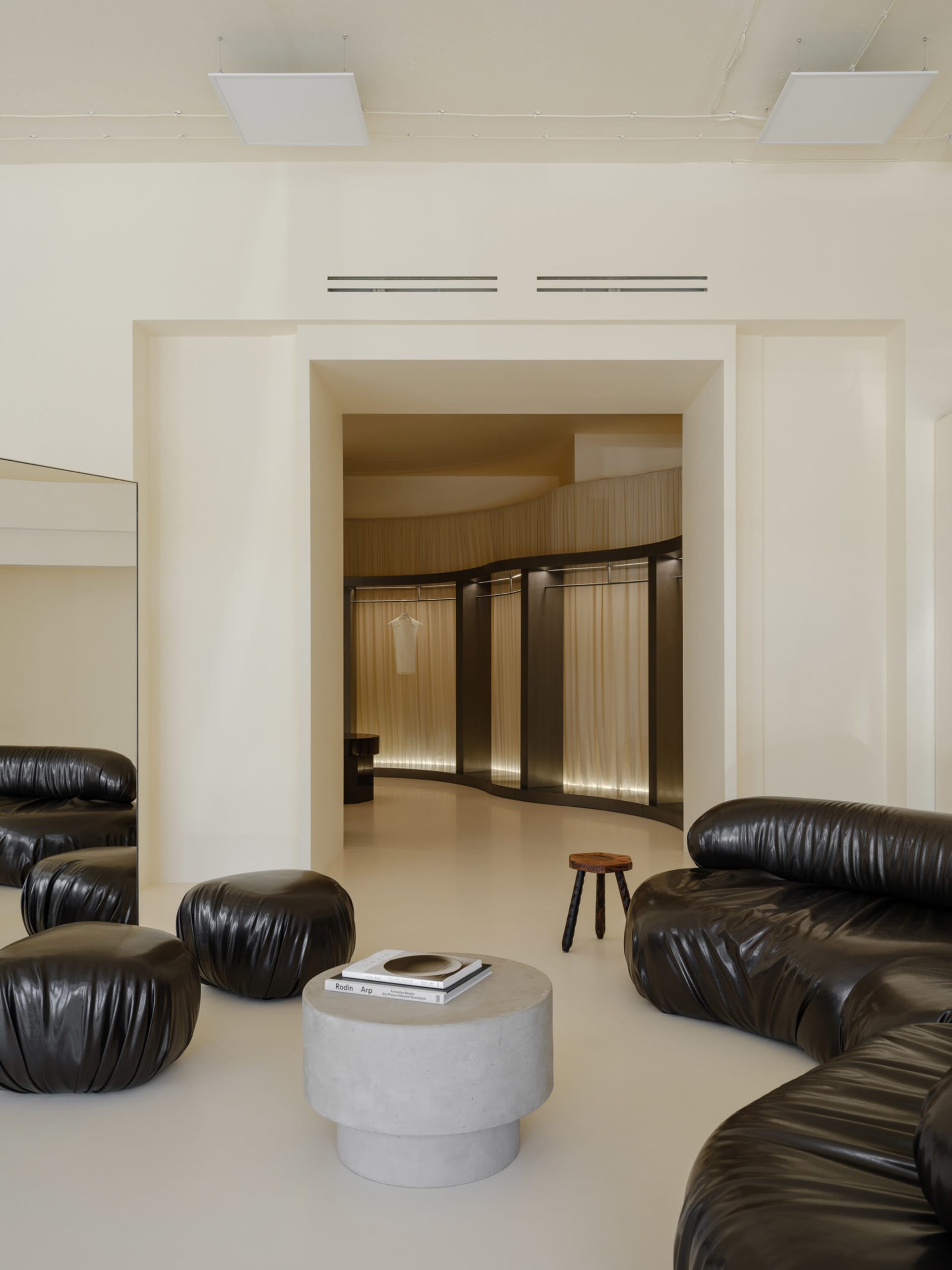 A modern retail store with concrete flooring and leather seating.
