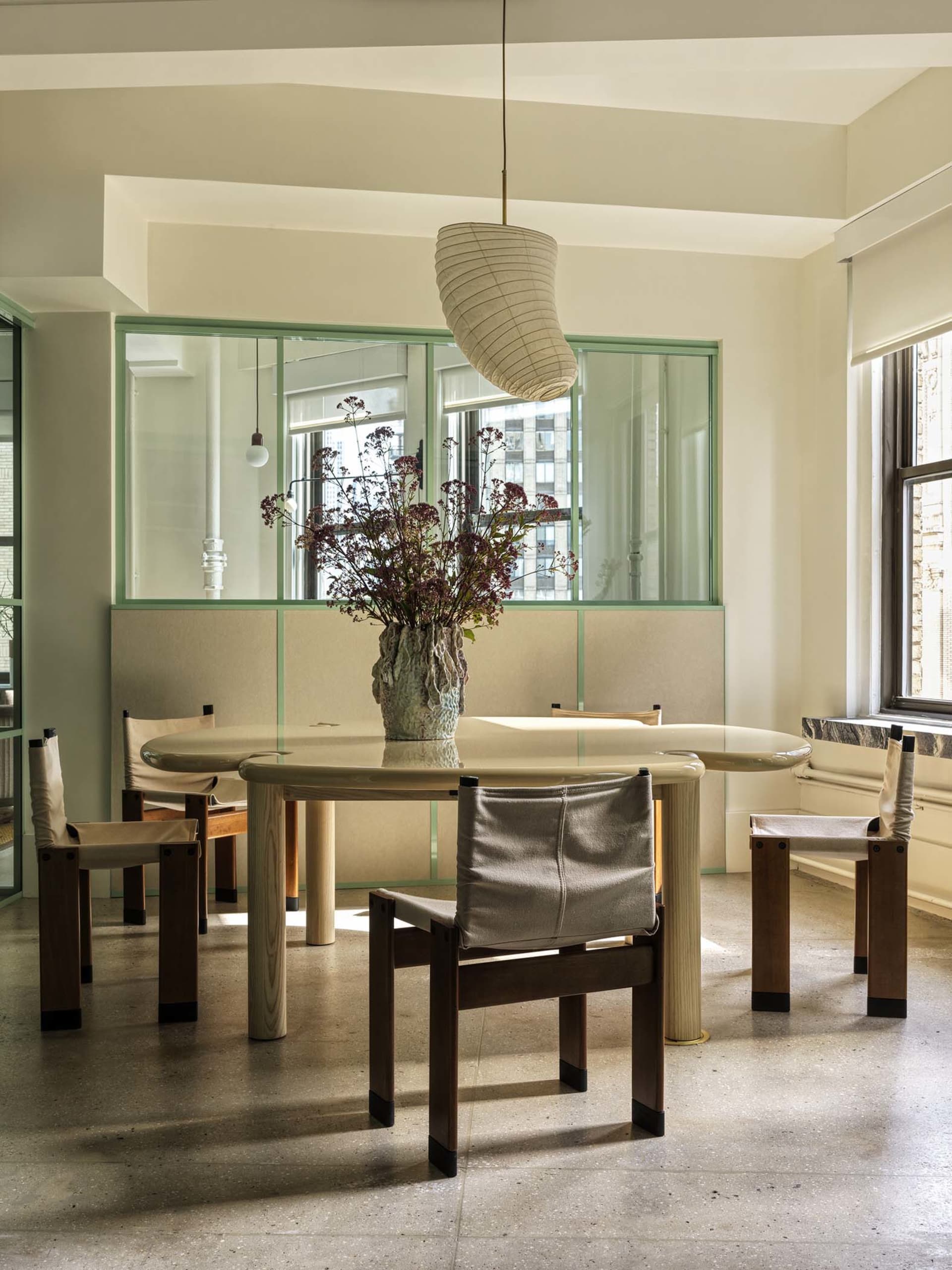 Modern dining room with an integrated glass window and wooden furniture.