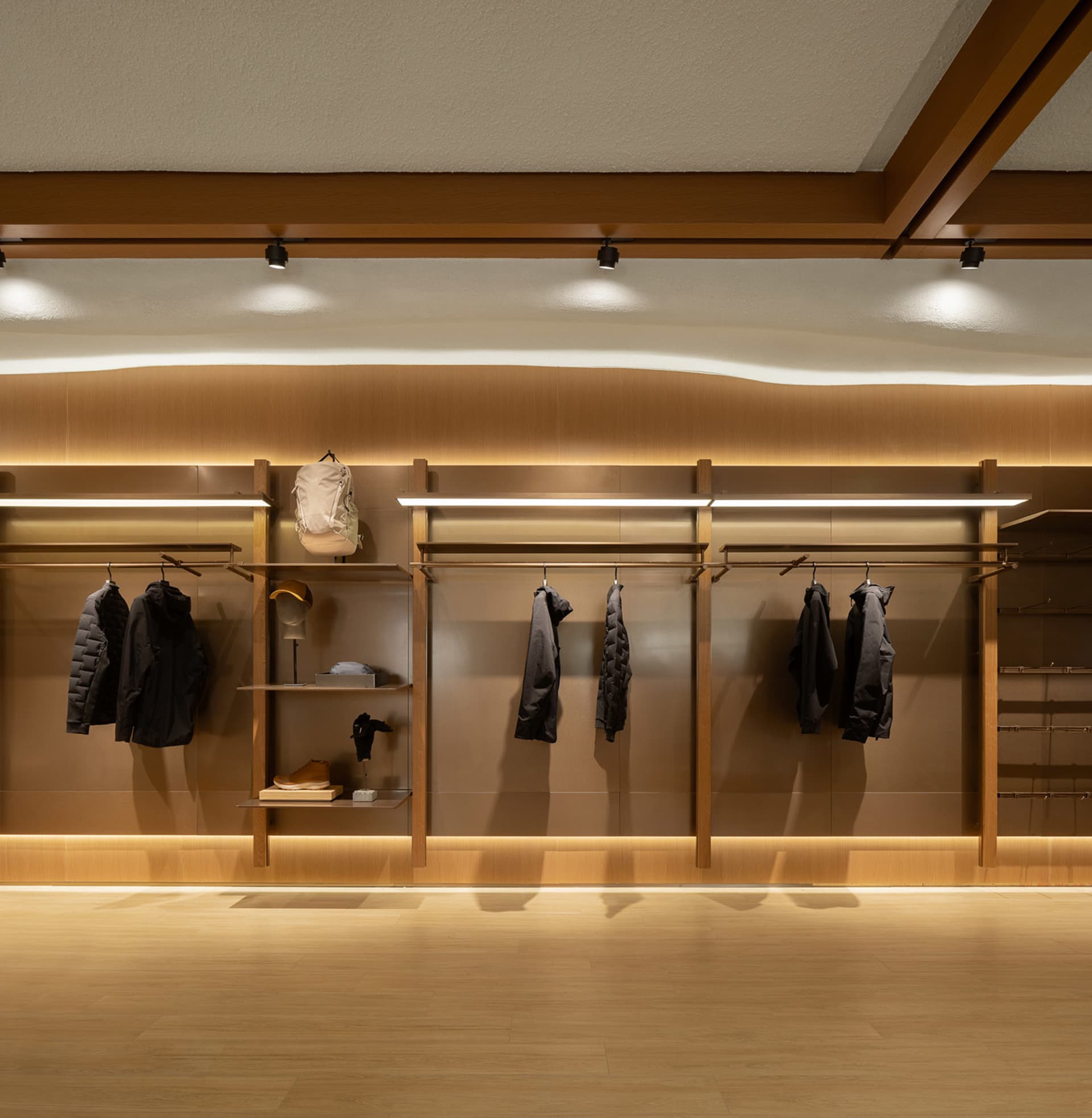 Well-lit retail space displaying modern clothing on racks and shelves.