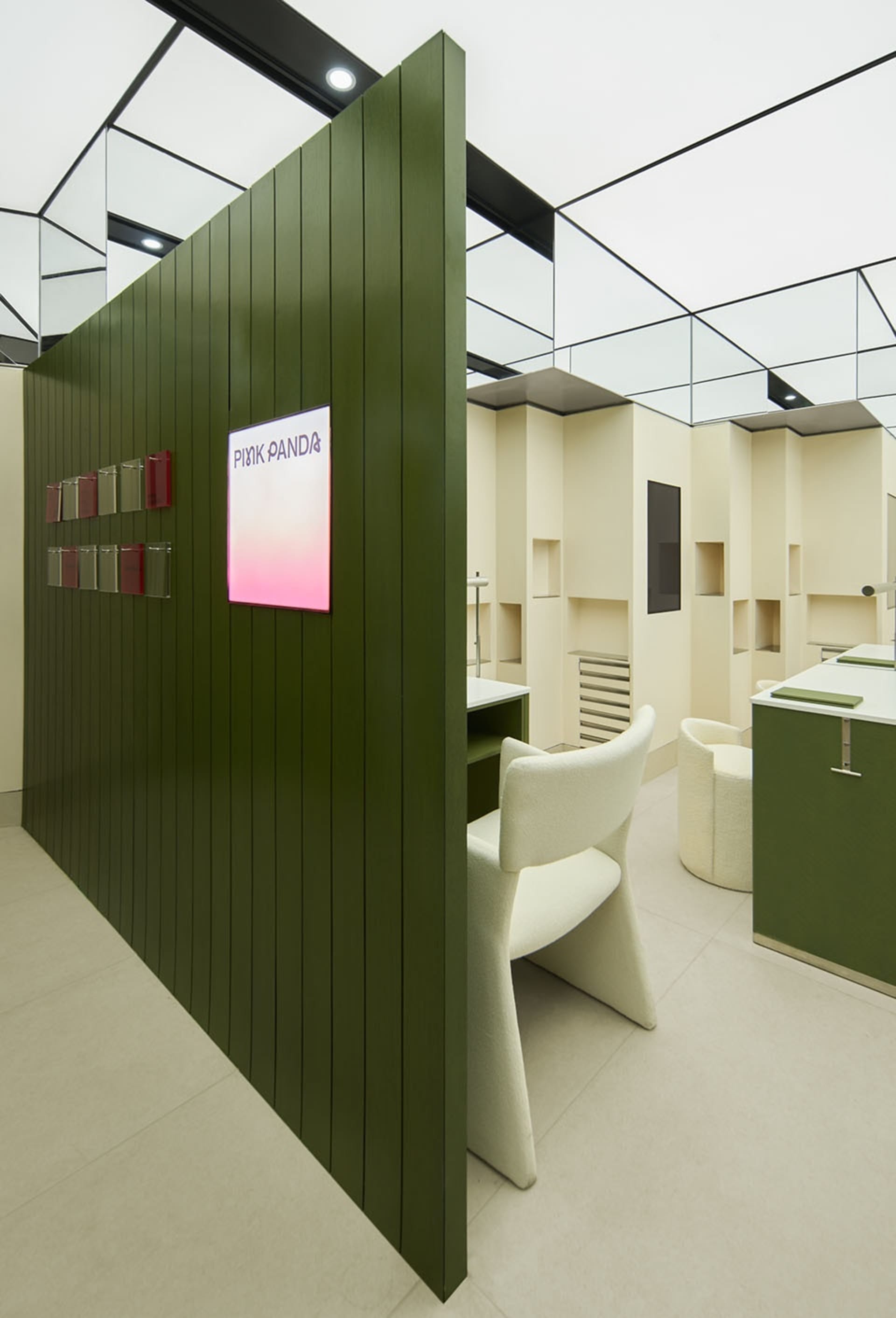 Modern office setting with green-painted walls and white furniture.