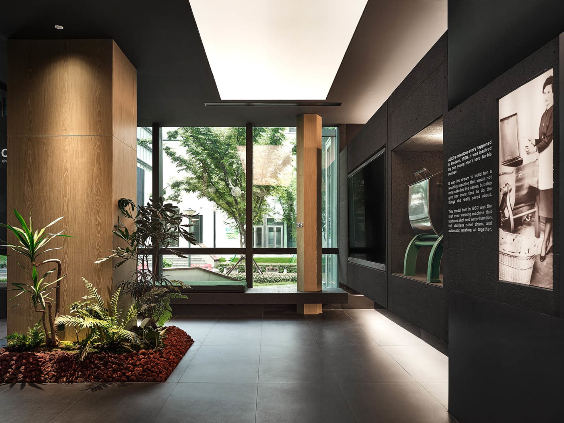 An indoor exhibit space featuring a modern design with concrete, glass, and steel materials.