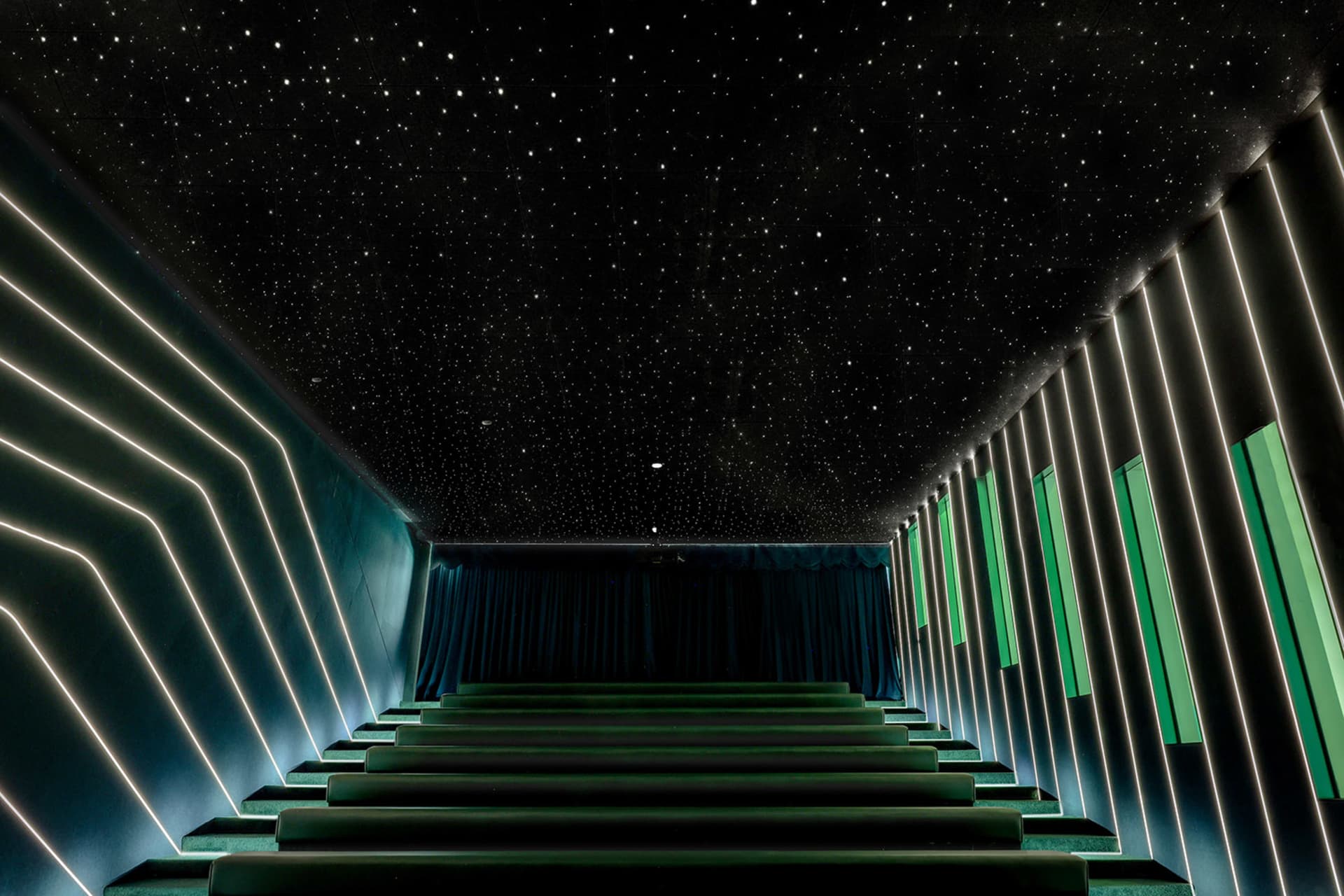 A modern cinema with concrete walls and neon lighting features.
