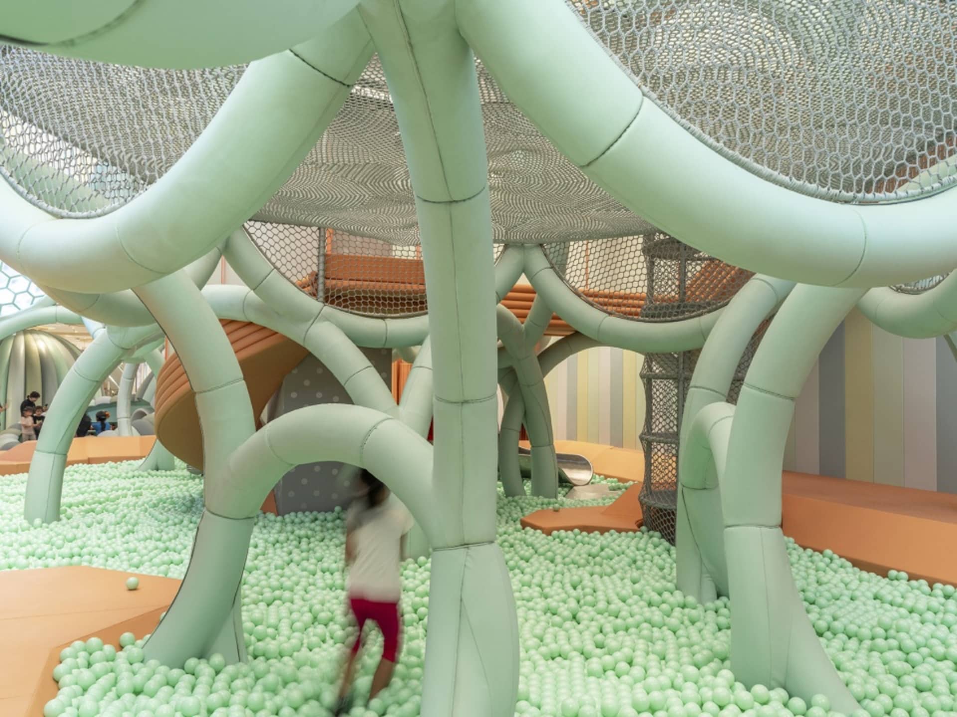 A modern playground designed with foam balls, mesh netting, and soft tubes for children's entertainment and physical activity