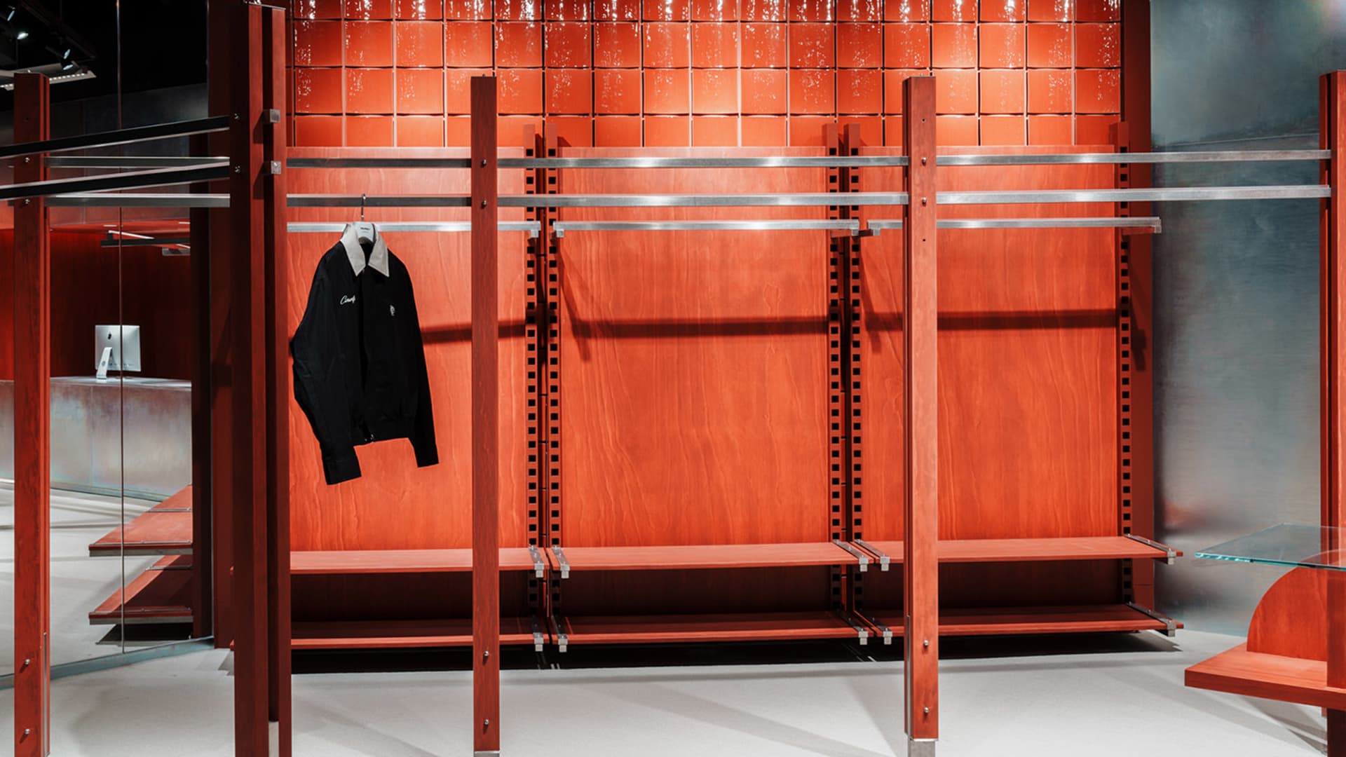 An empty retail display with a wooden structure, metal rails, and glass elements.